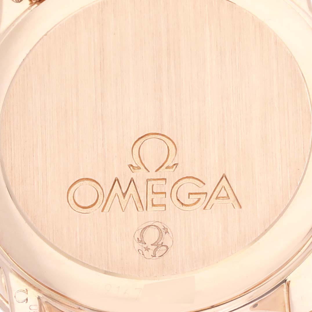 The image shows the case back of the Omega 4135.75.00 Women's Rose Gold Mother of Pearl Dial 4135.75.00 Women's Rose Gold Mother of Pearl Dial DeVille Prestige watch, highlighting the Omega 4135.75.00 Women's Rose Gold Mother of Pearl Dial 4135.75.00 Women's Rose Gold Mother of Pearl Dial logo engraved in rose gold.