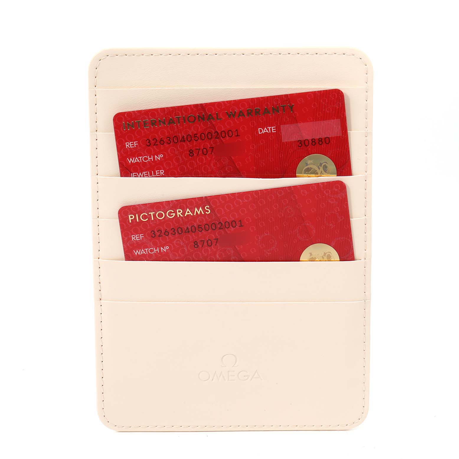 The image shows two red cards (International Warranty and Pictograms) in a cream Omega cardholder for a Speedmaster model by Omega.