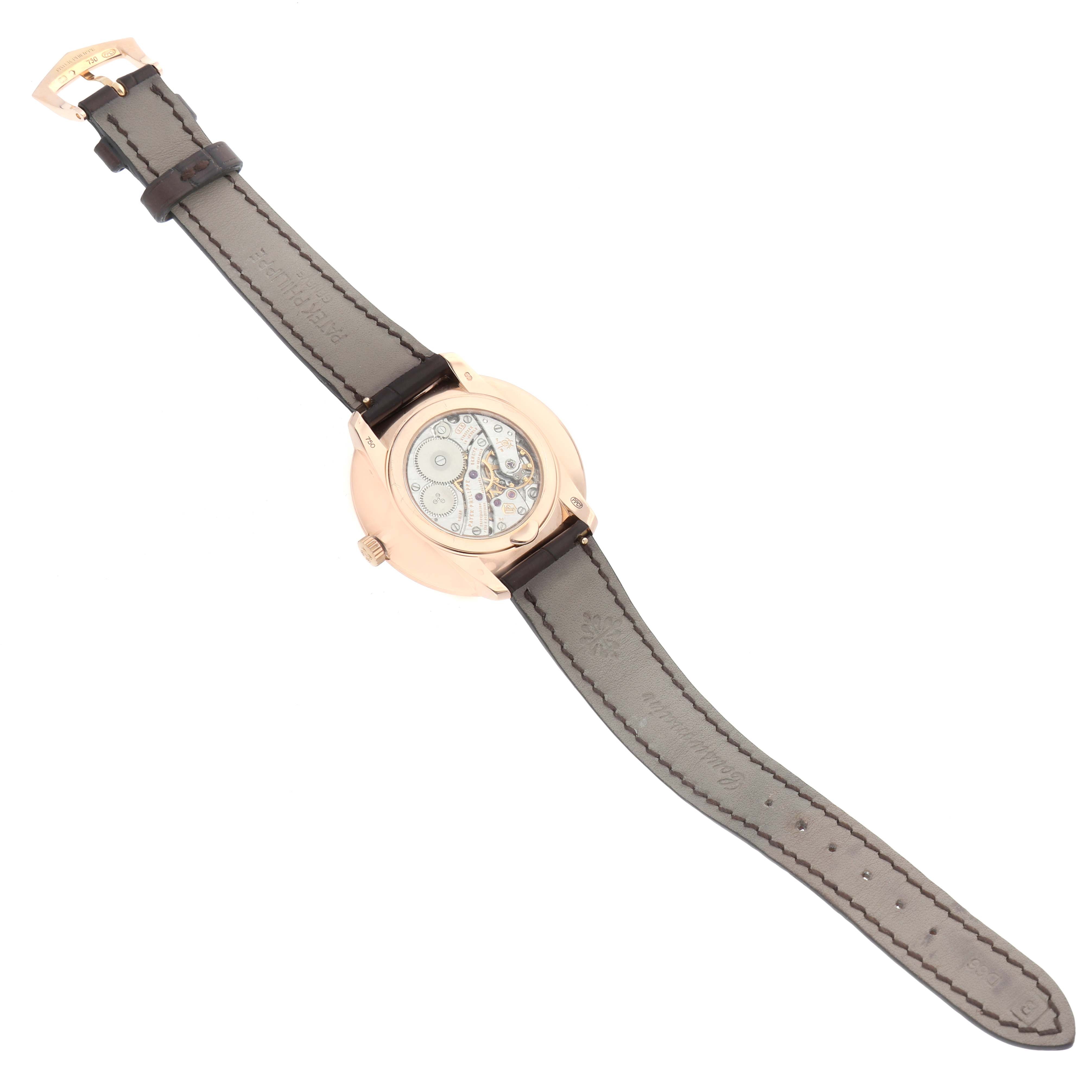 The Patek Philippe Calatrava 5123R Men's Rose Gold Silver Dial watch is shown from the back, highlighting the mechanical movement and leather strap.