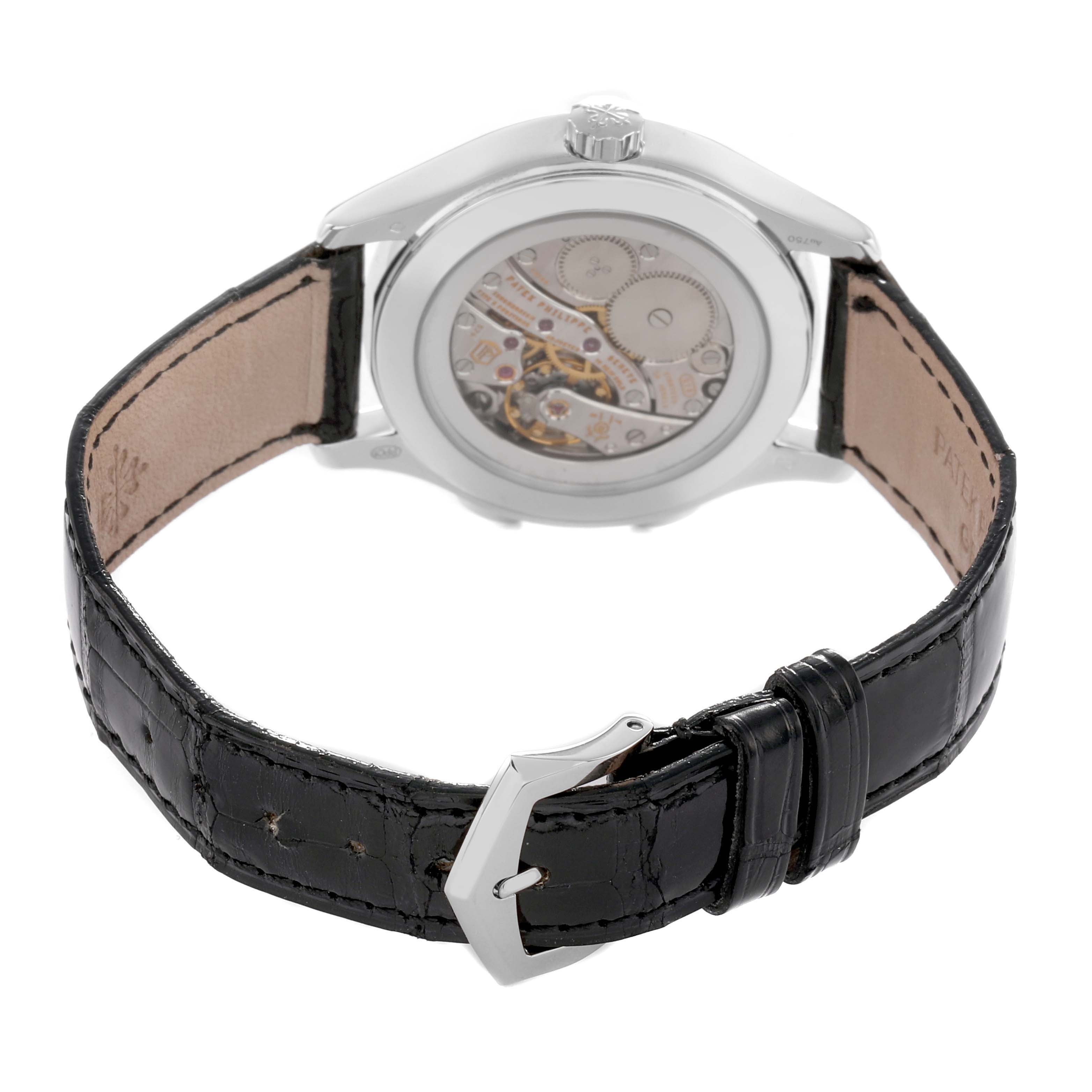 The Patek Philippe Calatrava 7134G Men's White Gold Brown Dial watch is shown from the back, highlighting the transparent case back and leather strap.