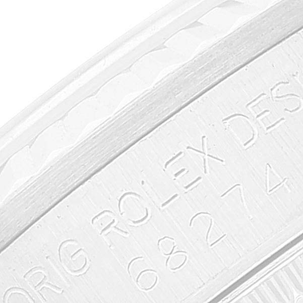 The image shows an extreme close-up of the engraved serial number on the side of a Rolex Mid-Size 68274 Women
s Stainless Steel Silver Dial 68274 Women
s Stainless Steel Silver Dial watch case.