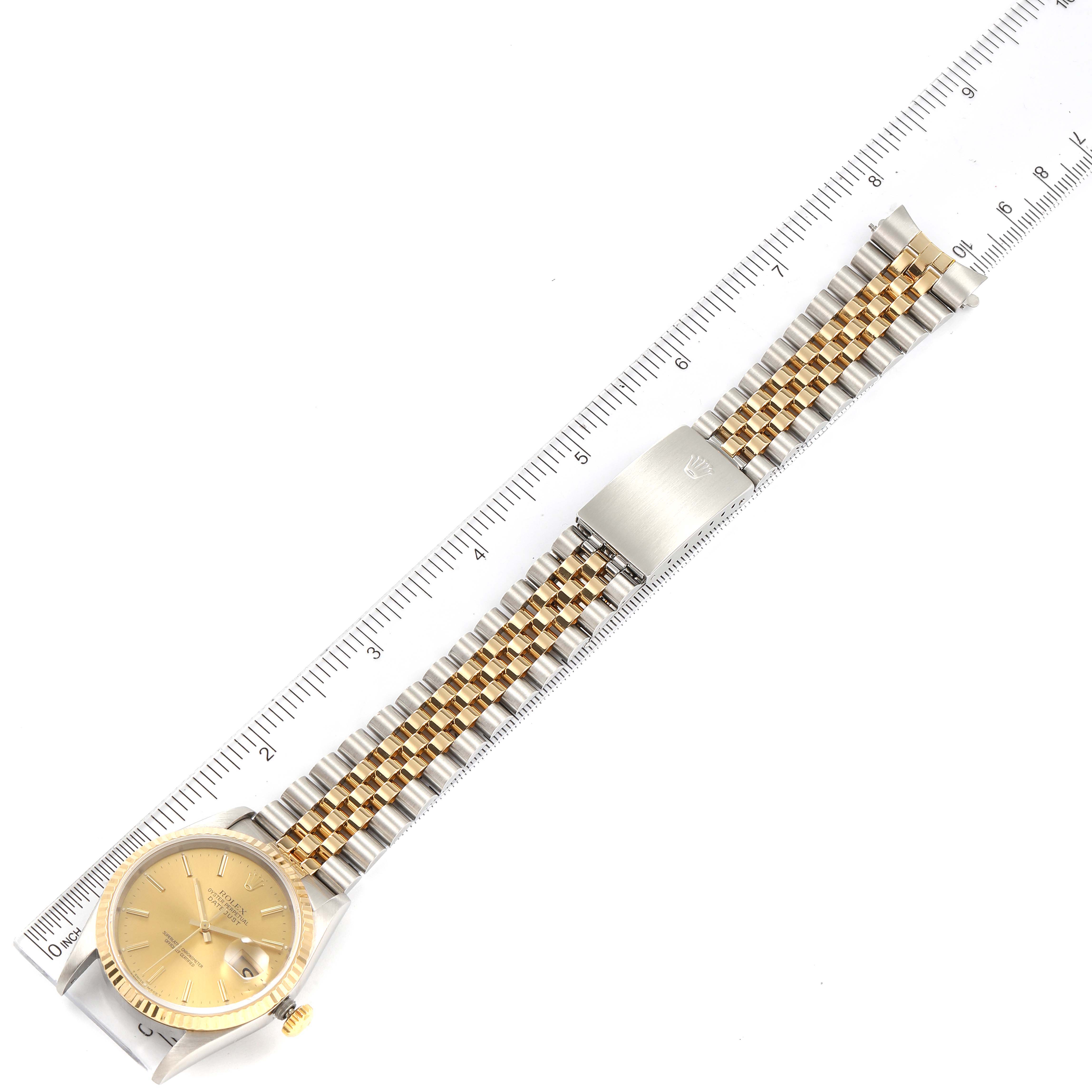 The image shows a Rolex Datejust 16233 Men's Steel and Gold (two tone) Champagne Dial 16233 Men's Steel and Gold (two tone) Champagne Dial model watch laid flat, showcasing its face, bracelet, and clasp along a ruler for scale.