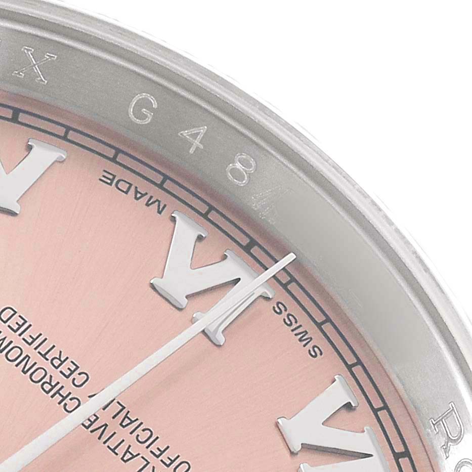 The image shows a close-up of the Rolex Datejust 116234 Men's Stainless Steel Pink Dial's dial and bezel, focusing on Roman numerals and part of the chapter ring.