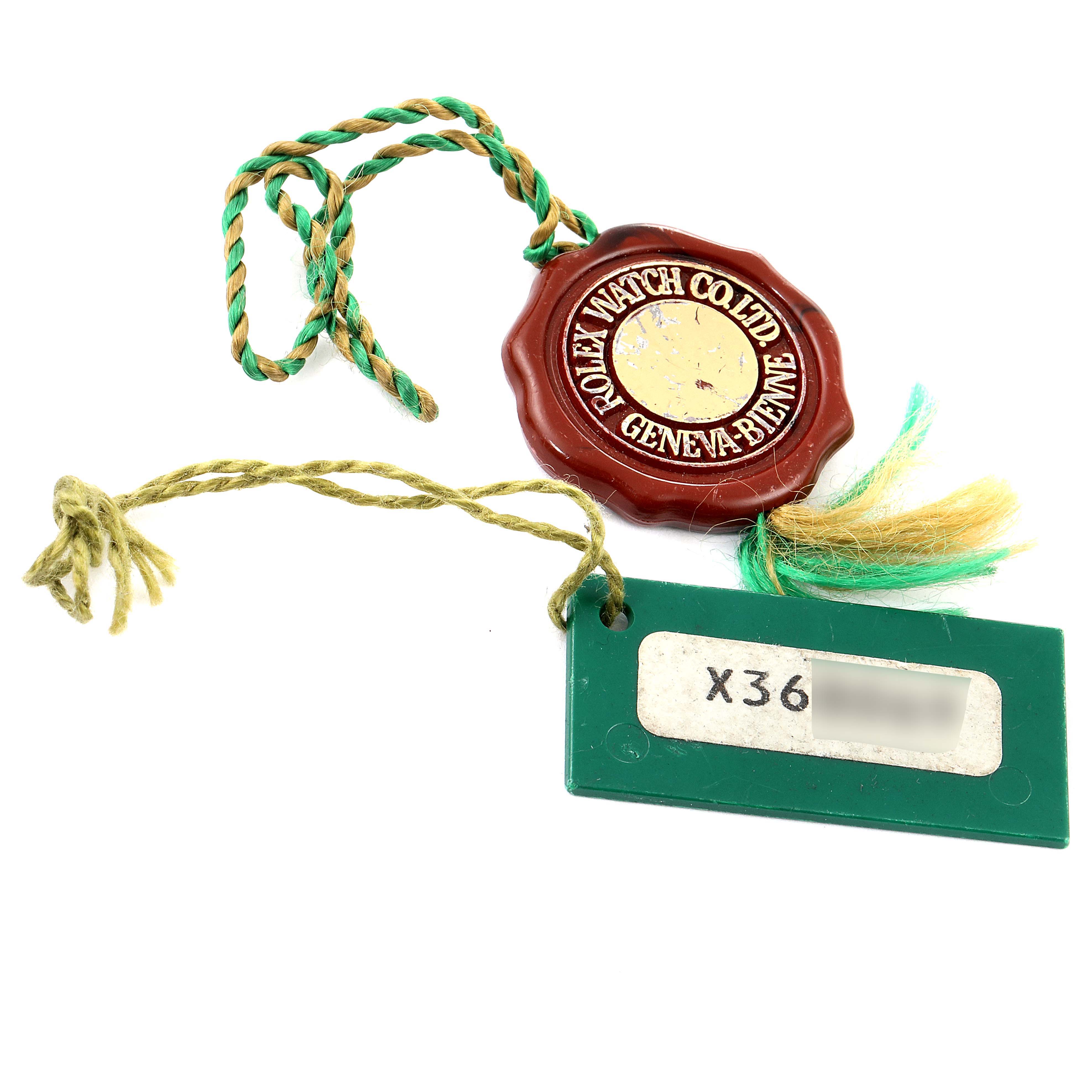 The image shows a Rolex Datejust 16233 Men's Steel and Gold (two tone) Black Dial 16233 Men's Steel and Gold (two tone) Black Dial model hang tag with a wax seal, green tag, and serial number on white paper.