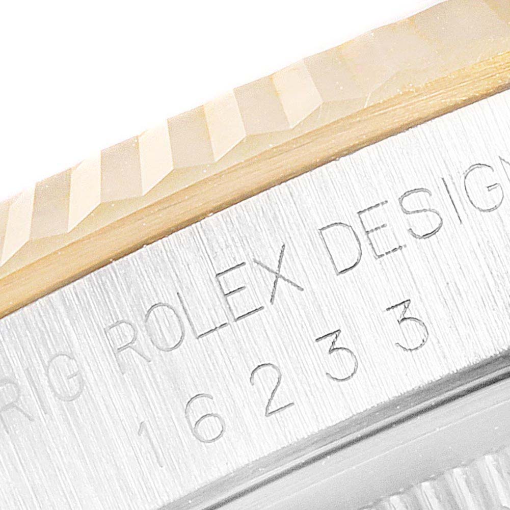This close-up image shows the engraved side of the Rolex Datejust 16233 Men's Steel and Gold (two tone) Black Dial 16233 Men's Steel and Gold (two tone) Black Dial model with partial view of its fluted bezel.