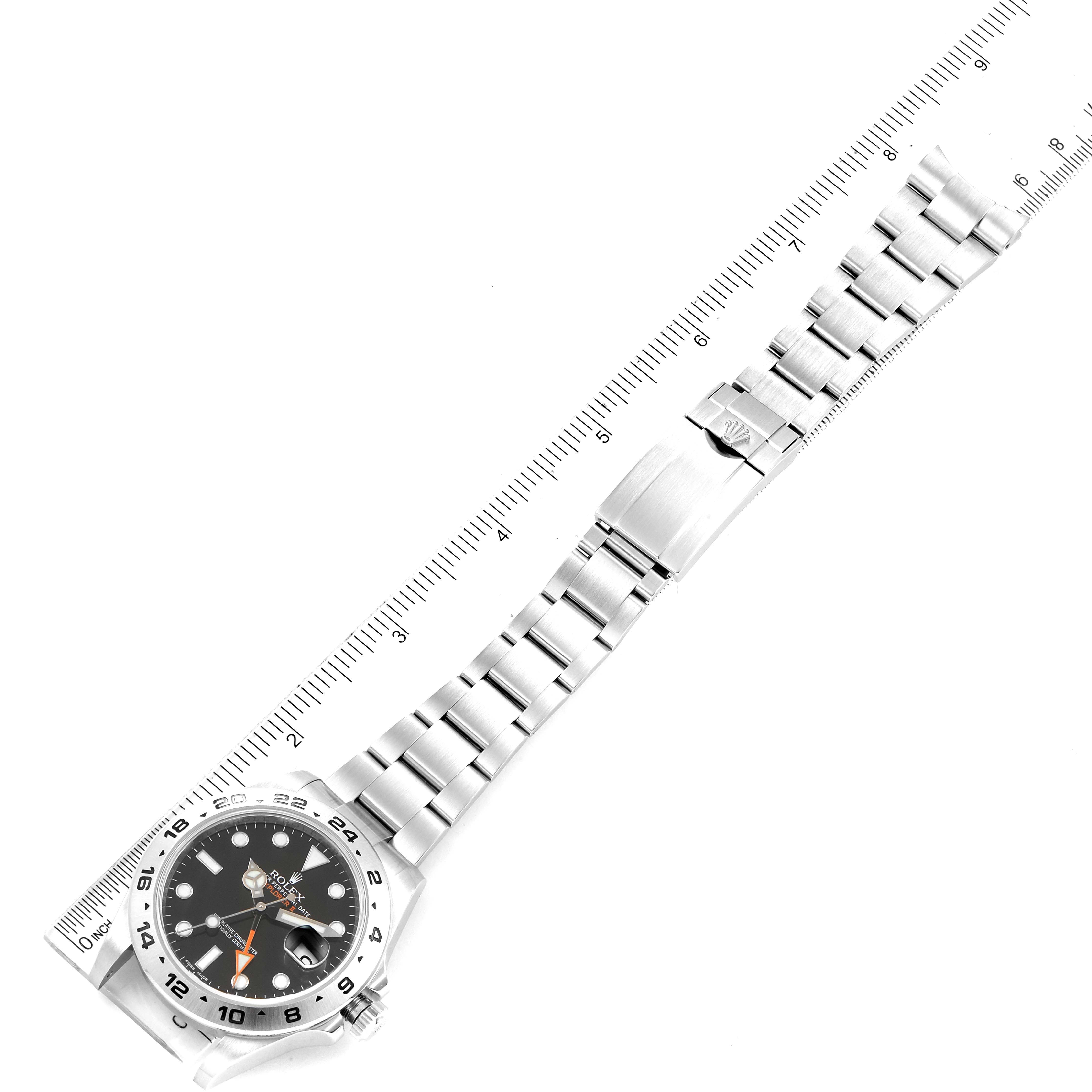 The Rolex Explorer 216570 Men's Stainless Steel Black Dial 216570 Men's Stainless Steel Black Dial watch is shown at a slight diagonal angle, displaying the face, bezel, bracelet, and clasp next to a ruler for scale.