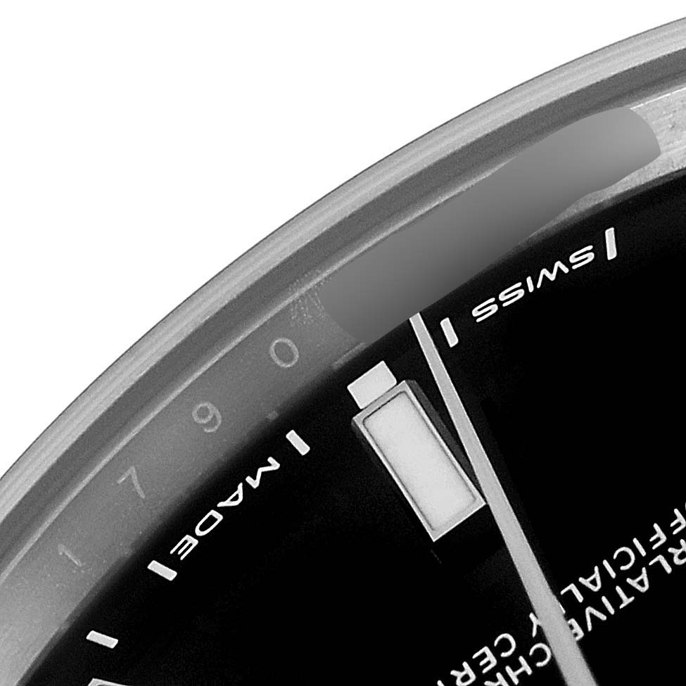 This close-up angle of a Rolex Oyster Perpetual 114300 Men
s Stainless Steel Black Dial 114300 Men
s Stainless Steel Black Dial watch shows part of the dial featuring the minute markers, Swiss label, and part of a hand.