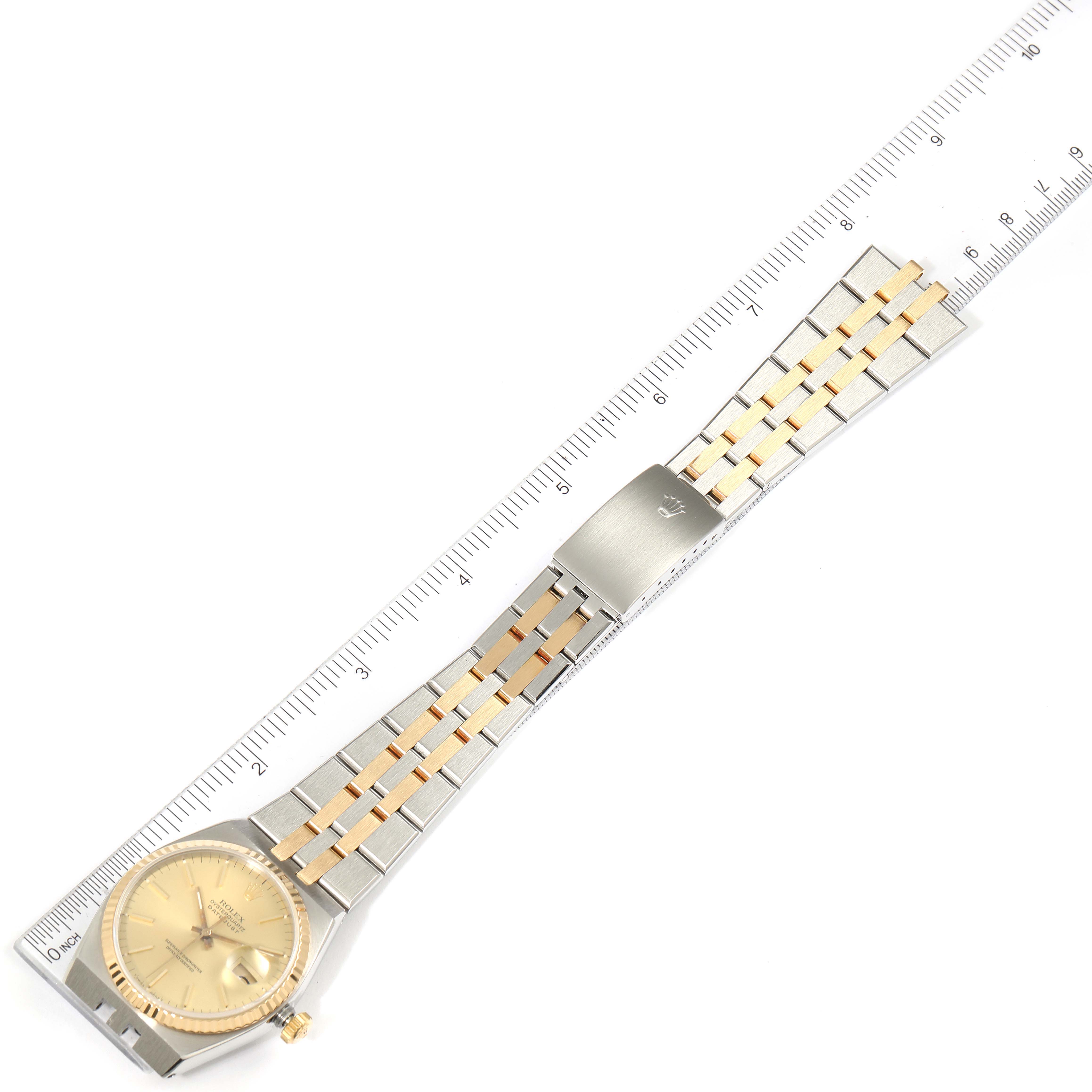 The image shows an overhead view of a Rolex Oysterquartz 17013 Men's Steel and Gold (two tone) Champagne Dial 17013 Men's Steel and Gold (two tone) Champagne Dial watch with its gold and silver bracelet extended alongside a ruler.