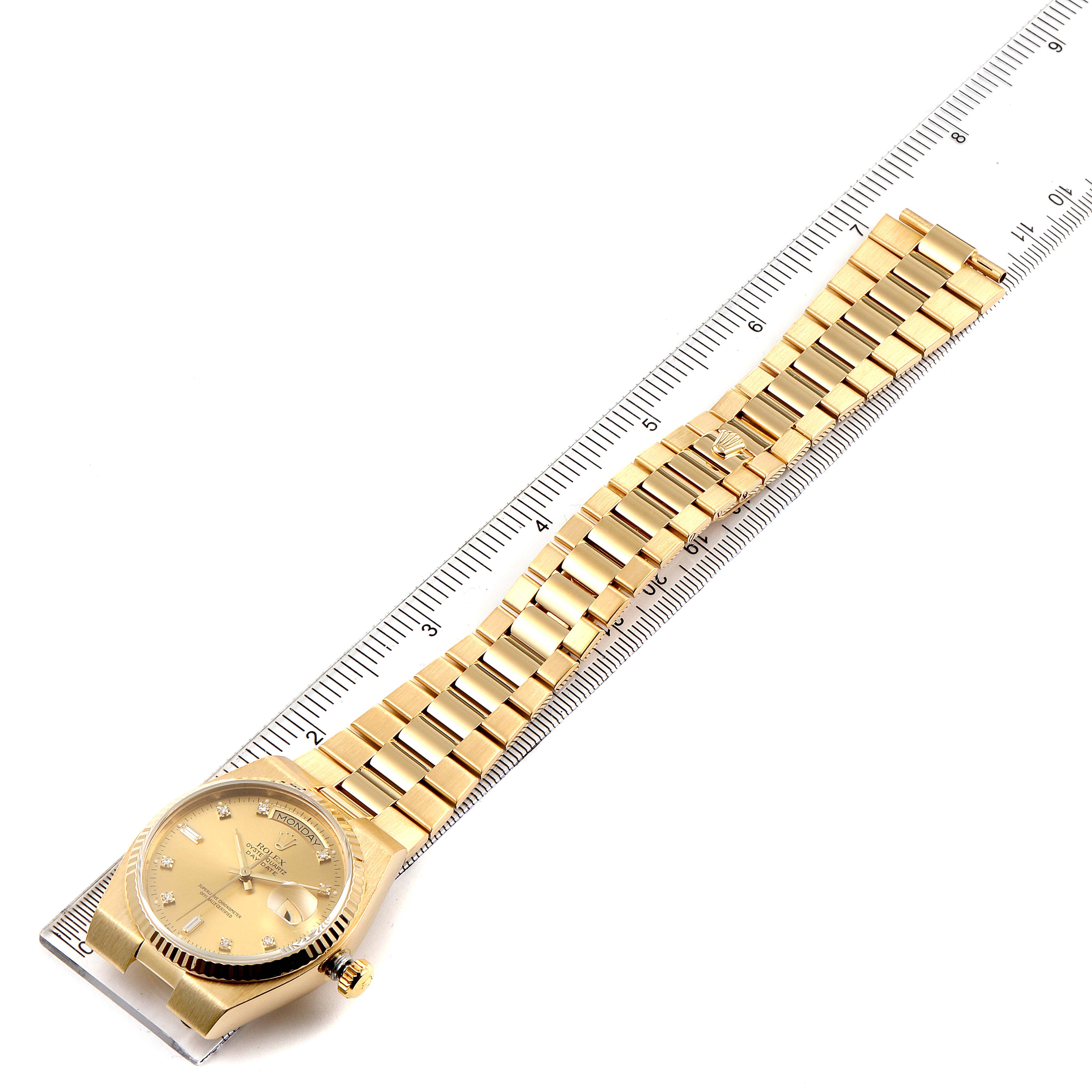 This image shows a Rolex Oysterquartz 19018 Men's Yellow Gold Champagne Dial 19018 Men's Yellow Gold Champagne Dial watch at a slight angle from above, displaying the face, bezel, bracelet, and some gradation marks on a ruler.