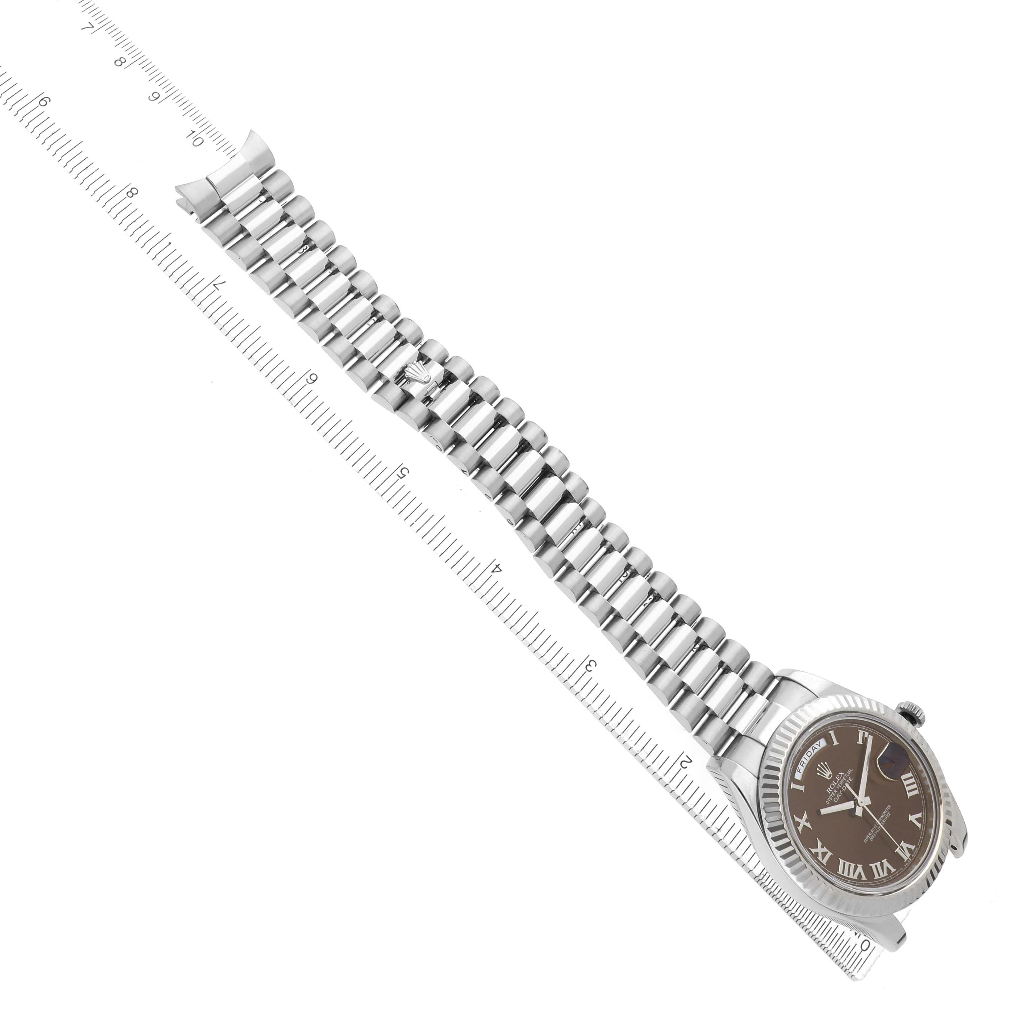 The Rolex President 218239 Men's White Gold Brown Dial watch is shown at an angle, displaying the band and face alongside a measuring ruler.
