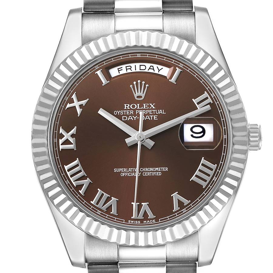 The image shows a front view of a Rolex President 218239 Men's White Gold Brown Dial model watch, highlighting the brown dial, Roman numerals, day, and date display.