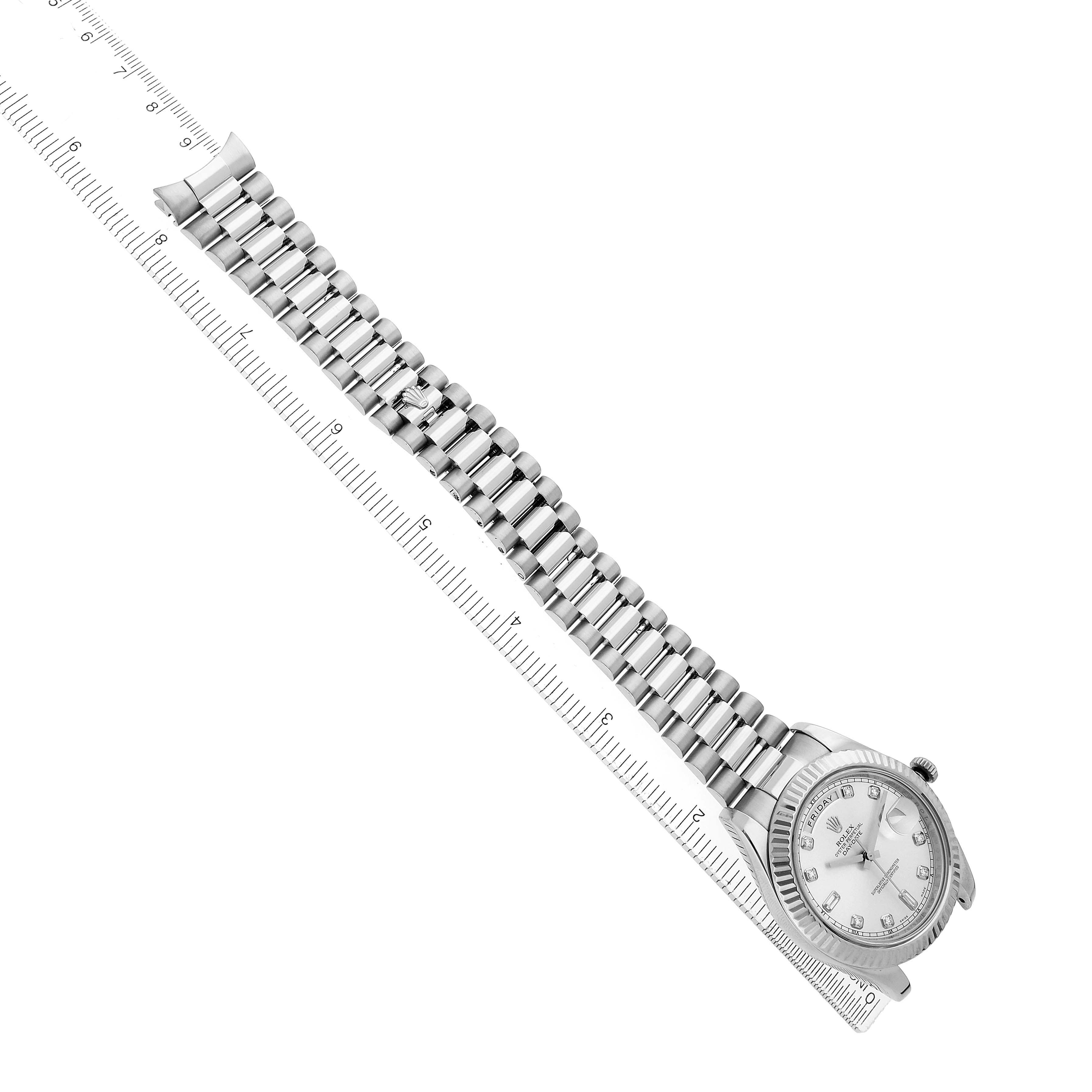 The Rolex President 218239 Men's White Gold Silver Dial model is shown from a top view, featuring the watch face and full linked bracelet alongside a ruler.