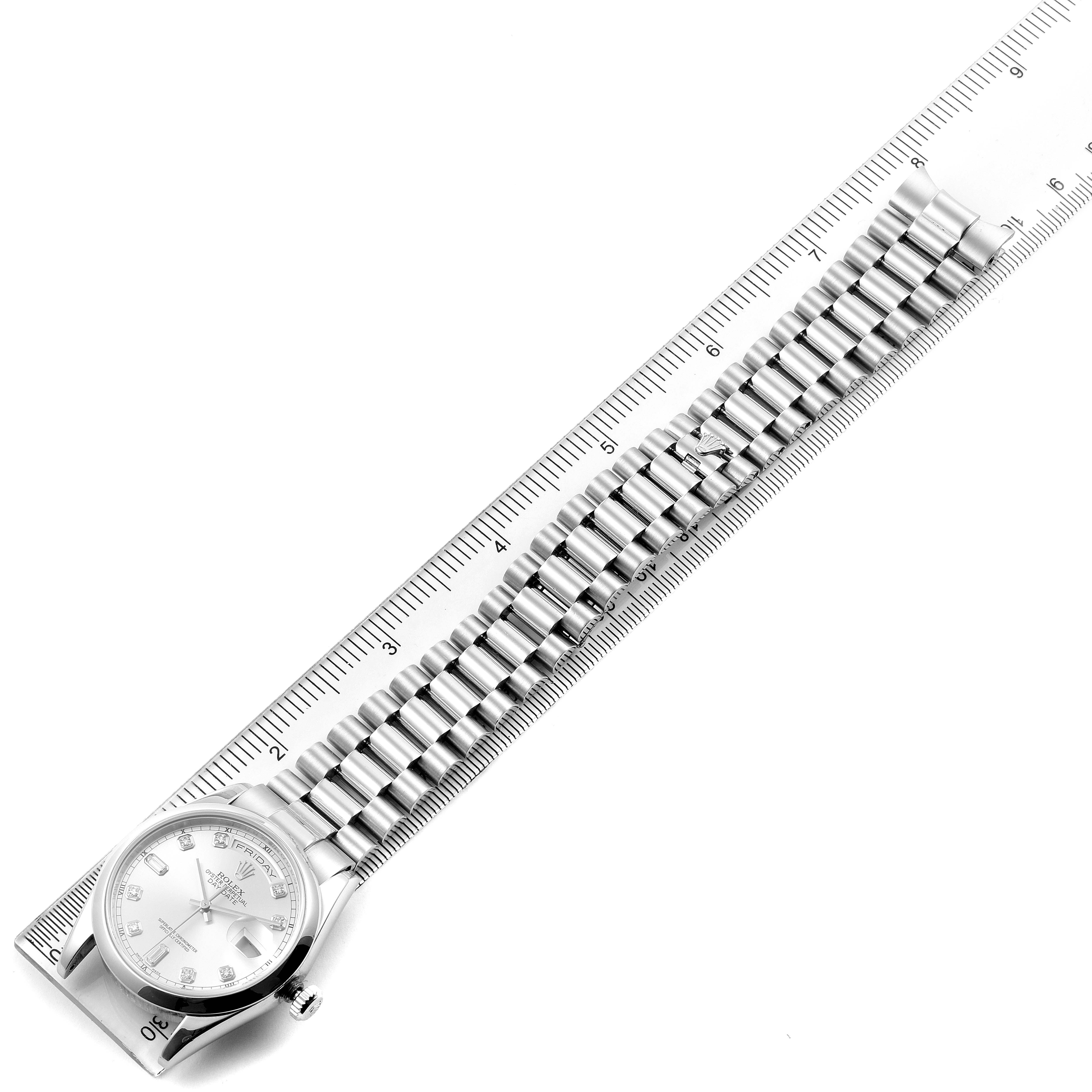 The Rolex President 118206 Men's Platinum Silver Dial 118206 Men's Platinum Silver Dial watch is shown from a top-down angle, displaying the dial and entire bracelet alongside a ruler.