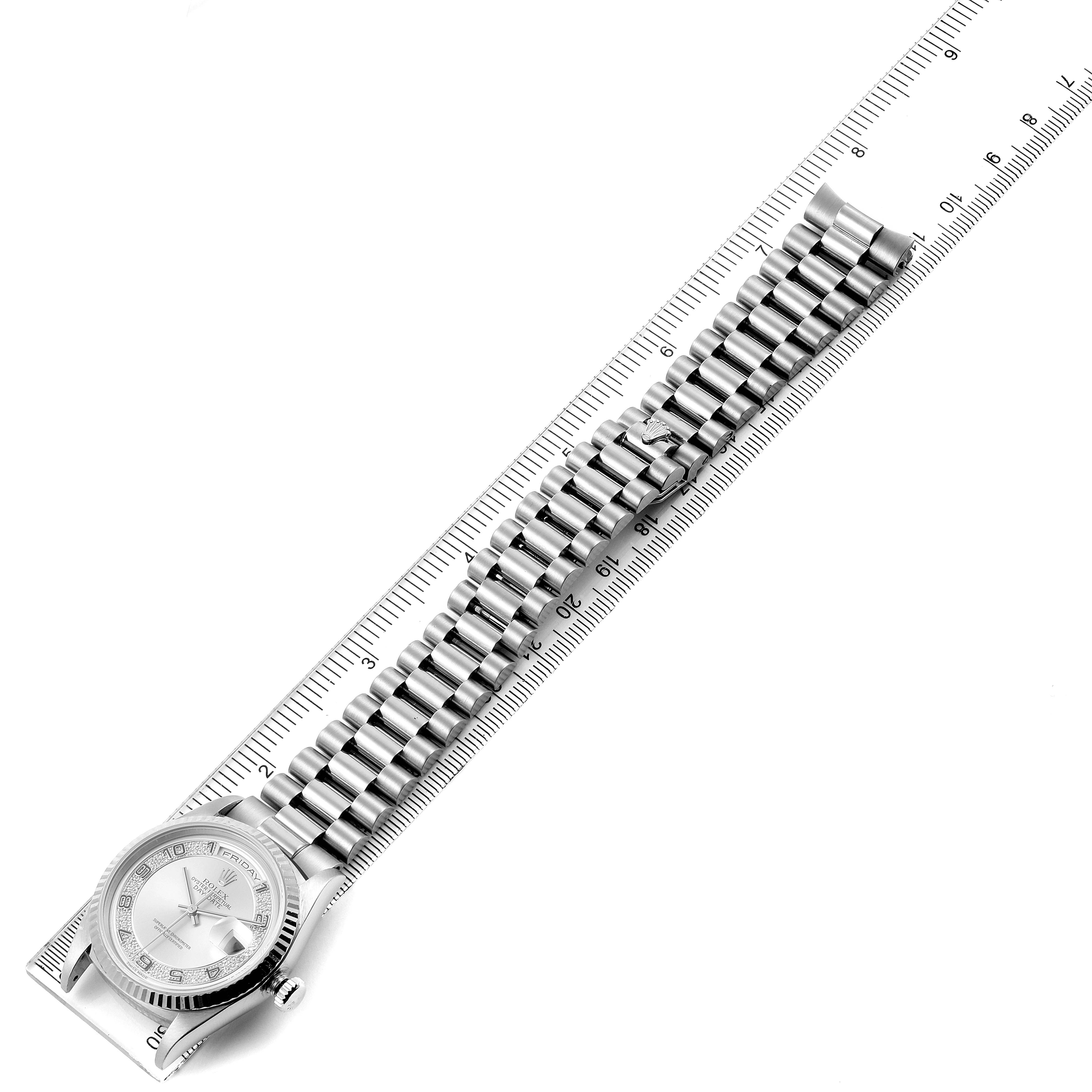 The image shows the President model Rolex watch from a top-down angle, highlighting the bracelet and watch bezel along a ruler.