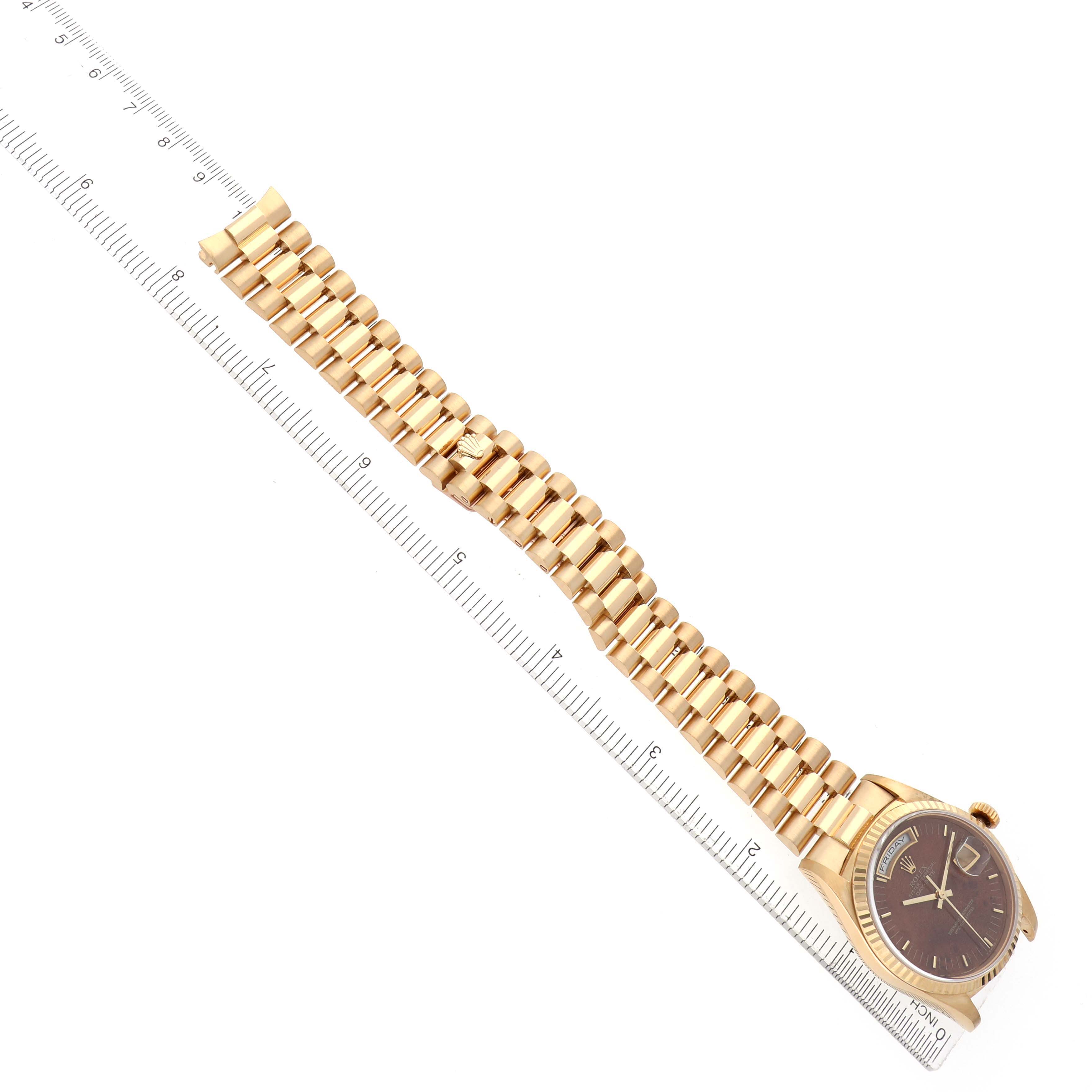 The image shows a Rolex President 18238 Men's Yellow Gold Brown Dial watch at an angle, featuring its gold bracelet, dial, and partial ruler for sizing reference.