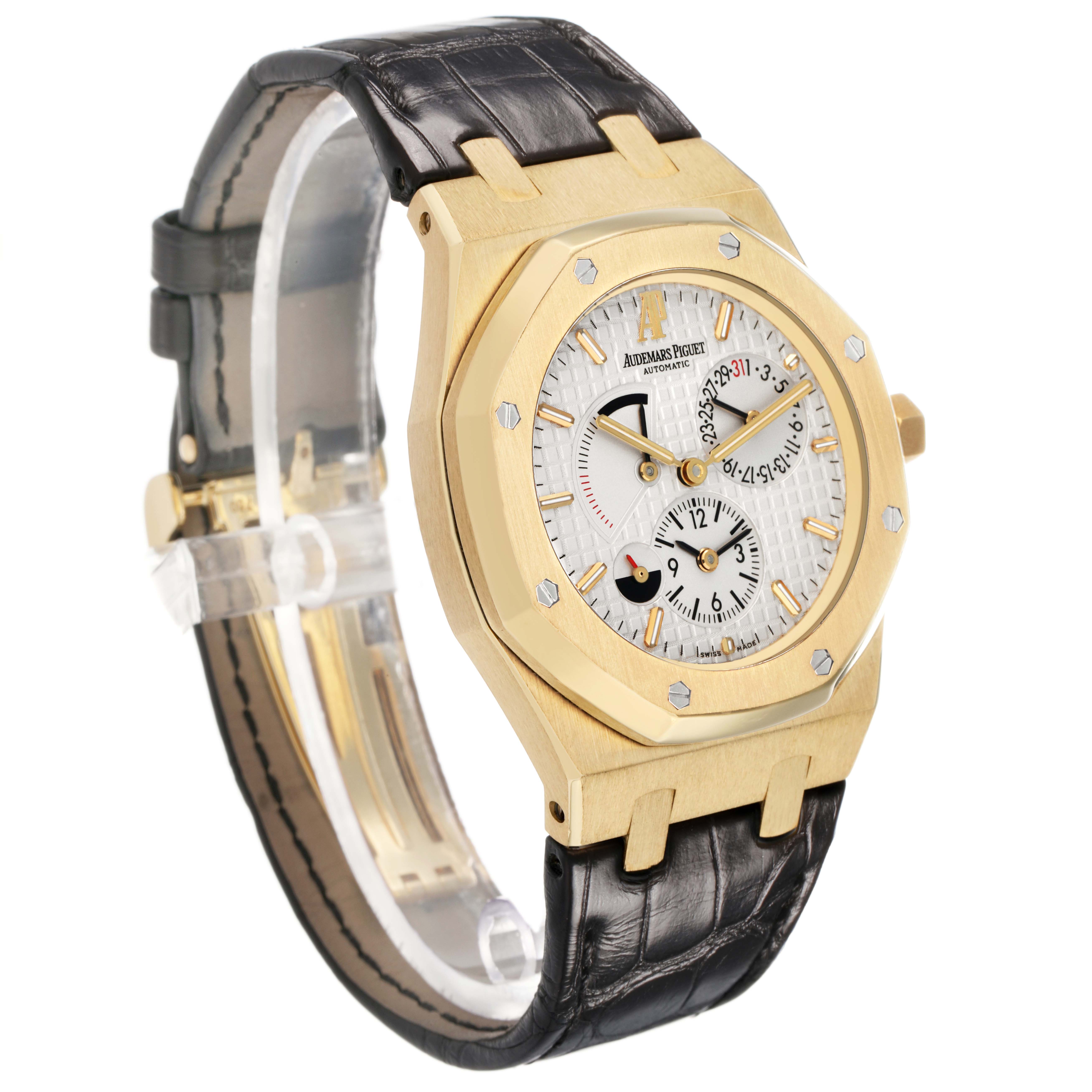 The image shows an angled view of the Audemars Piguet Royal Oak 26120BA Men's Yellow Gold Silver Dial watch, highlighting the face, bezel, and leather strap.