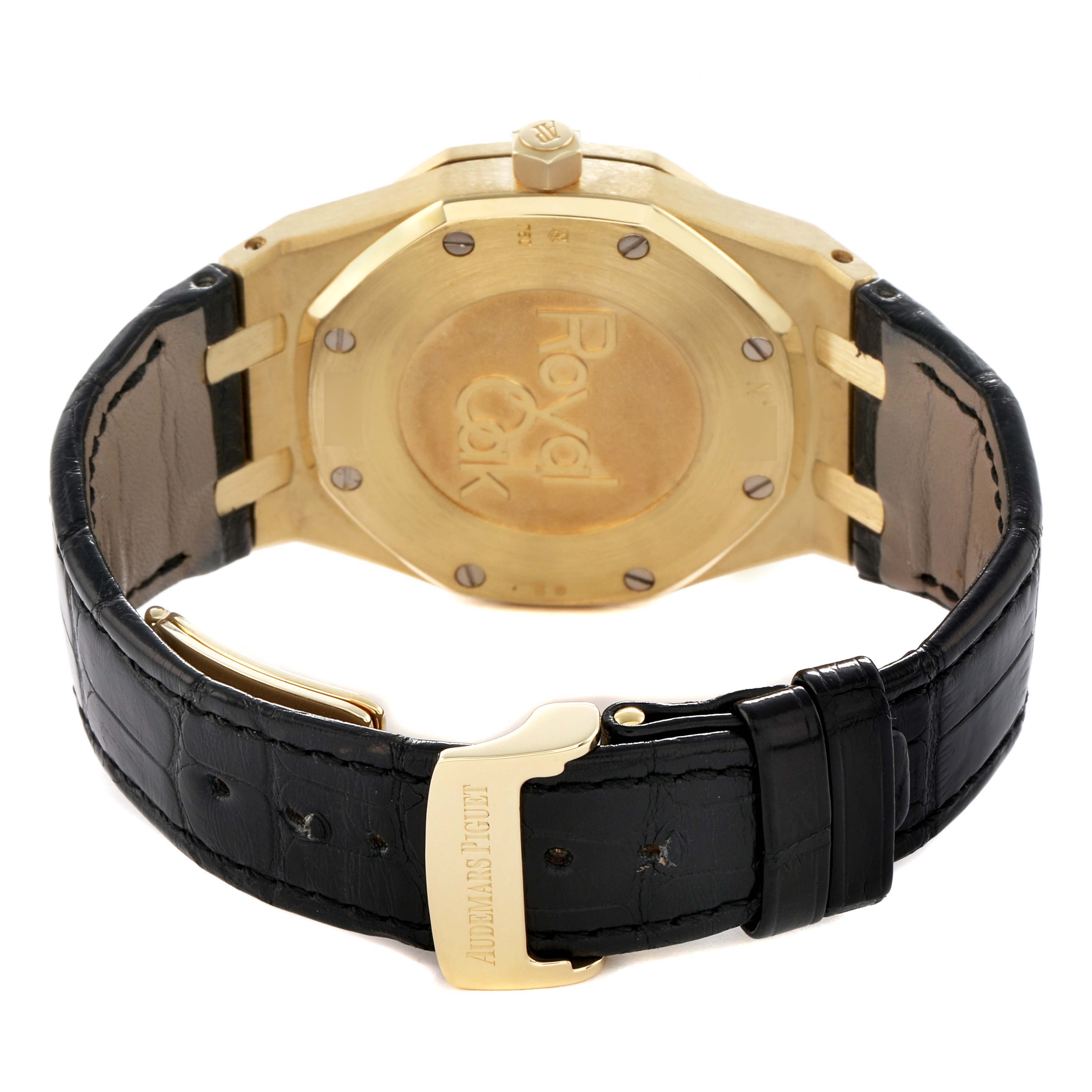 The image shows the case back and clasp of an Audemars Piguet Royal Oak 26120BA Men's Yellow Gold Silver Dial watch, highlighting the brand's name and design.