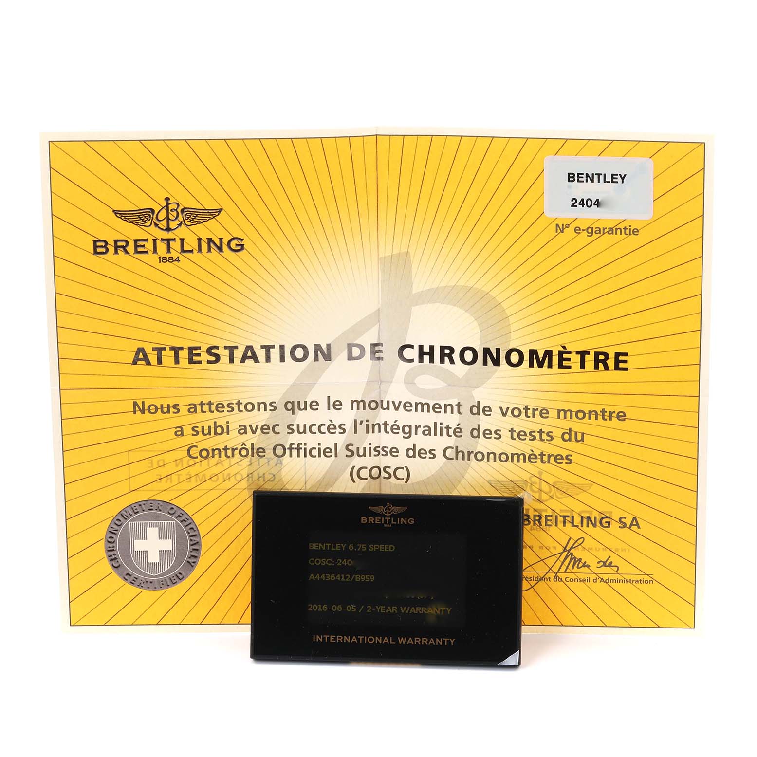 The image shows a Bentley model Breitling watch warranty card and chronometer certificate from a front angle.