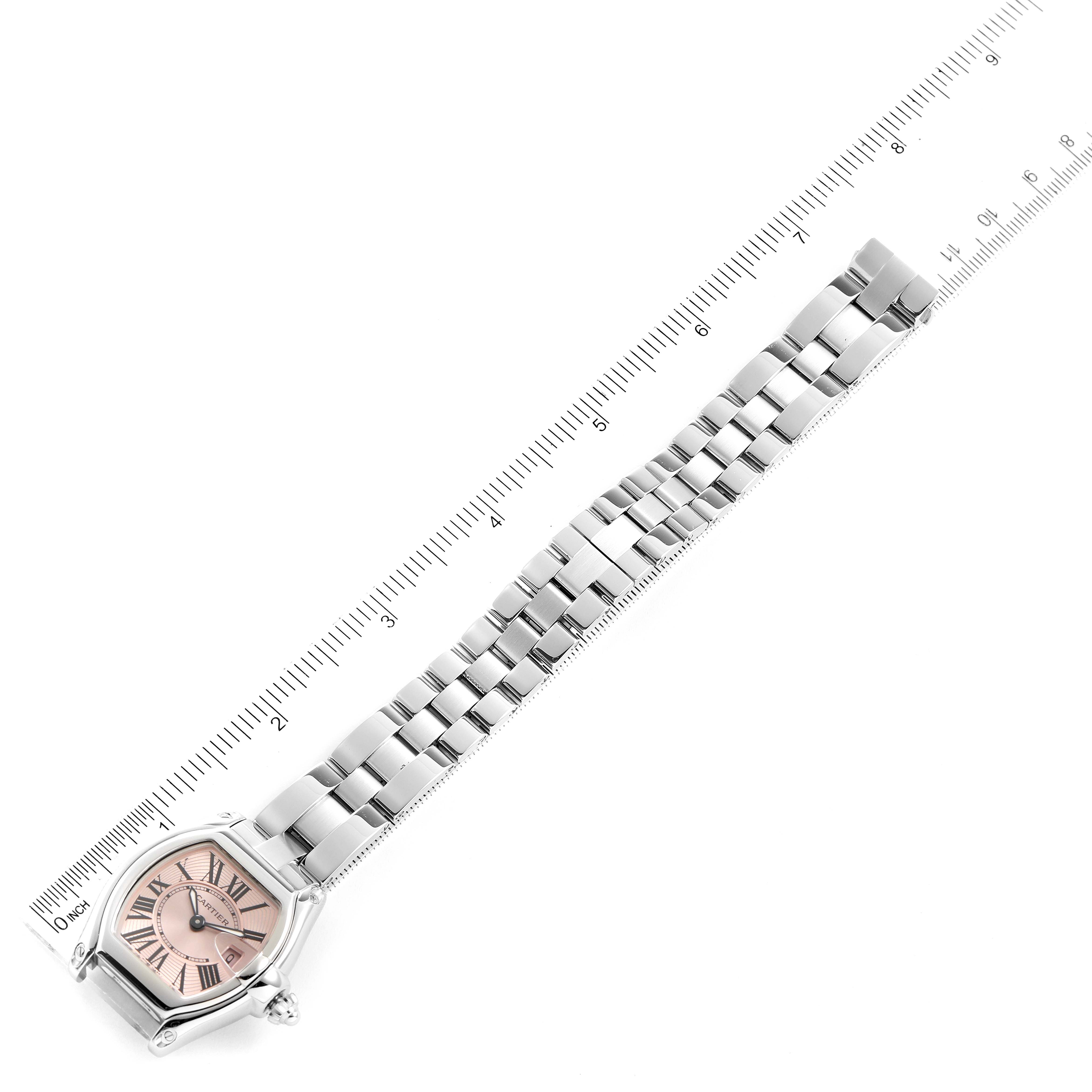 The Cartier Roadster W62017V3 Women's Stainless Steel Pink Dial W62017V3 Women's Stainless Steel Pink Dial watch is shown from a top-down angle, displaying its face, strap, and a ruler for scale.