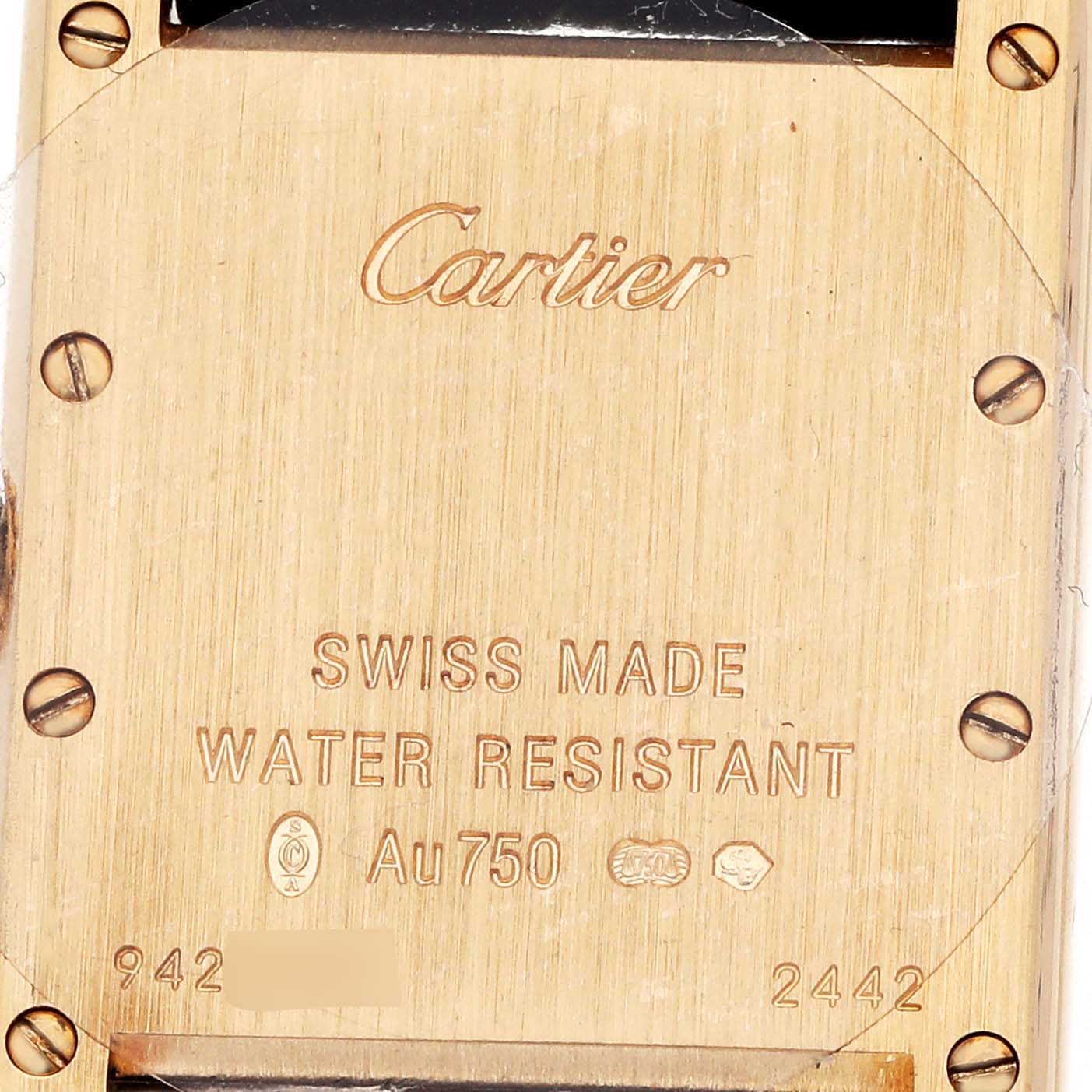 The image shows the back plate of a Cartier Tank Louis W1529856 Women's Yellow Gold Silver Dial watch, highlighting its engravings and screws.
