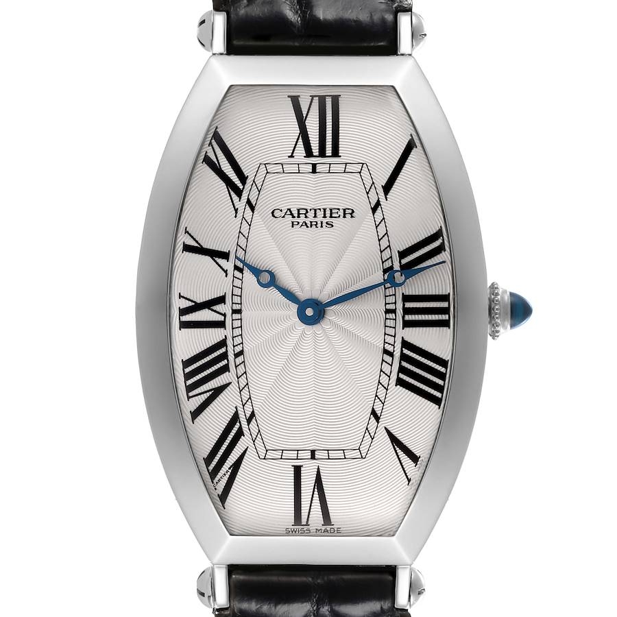 The Cartier Tonneau watch is shown from the front, highlighting its elongated case, Roman numerals, and blue hands.