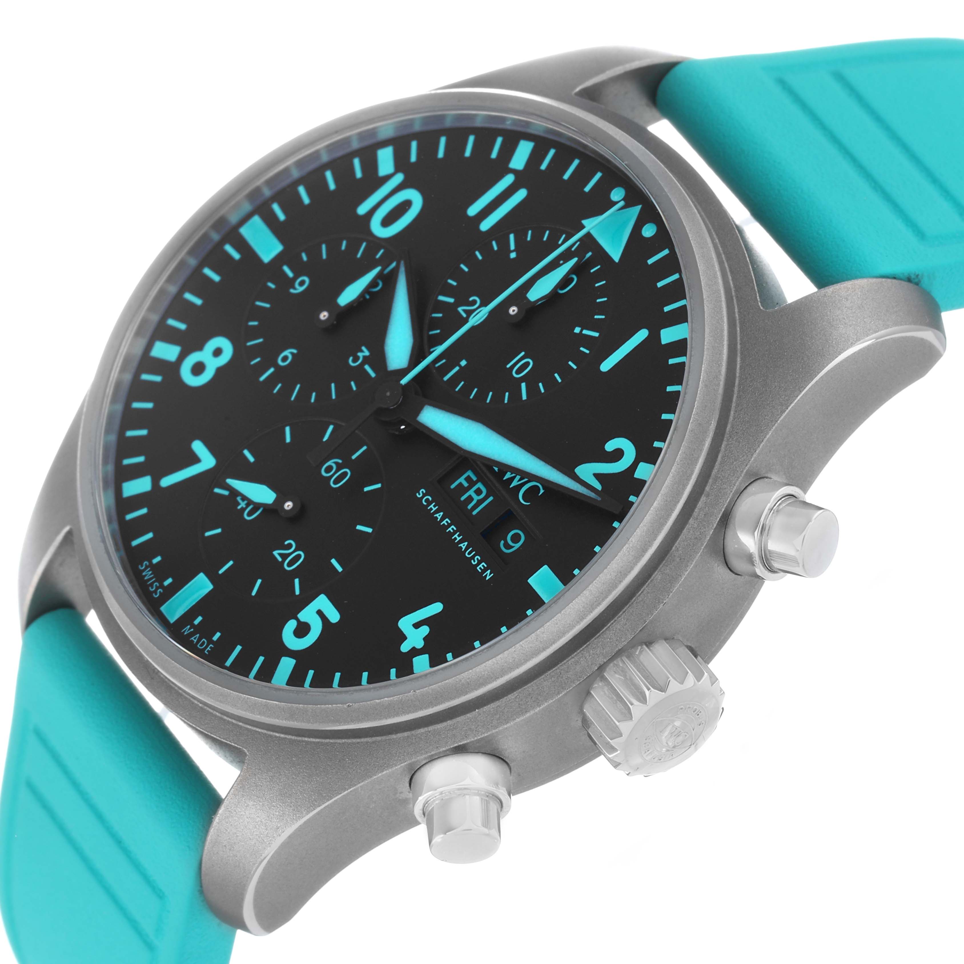 The IWC Pilot IW388108 Men's Titanium Black Dial watch is shown at an angle showcasing the face, pushers, crown, and turquoise strap.