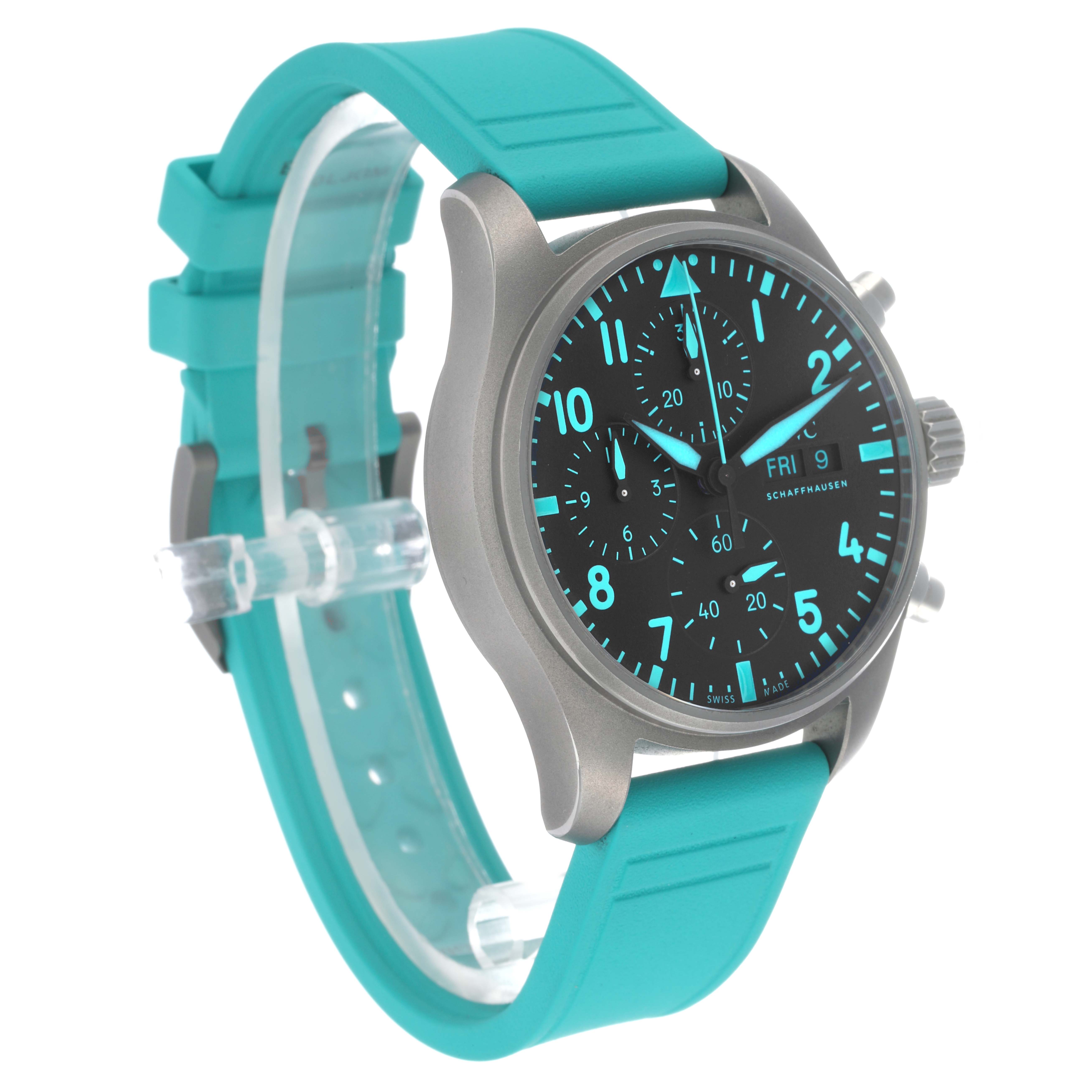 The IWC Pilot IW388108 Men's Titanium Black Dial watch shows a side and front angle, highlighting the turquoise strap, dial, and pushers.