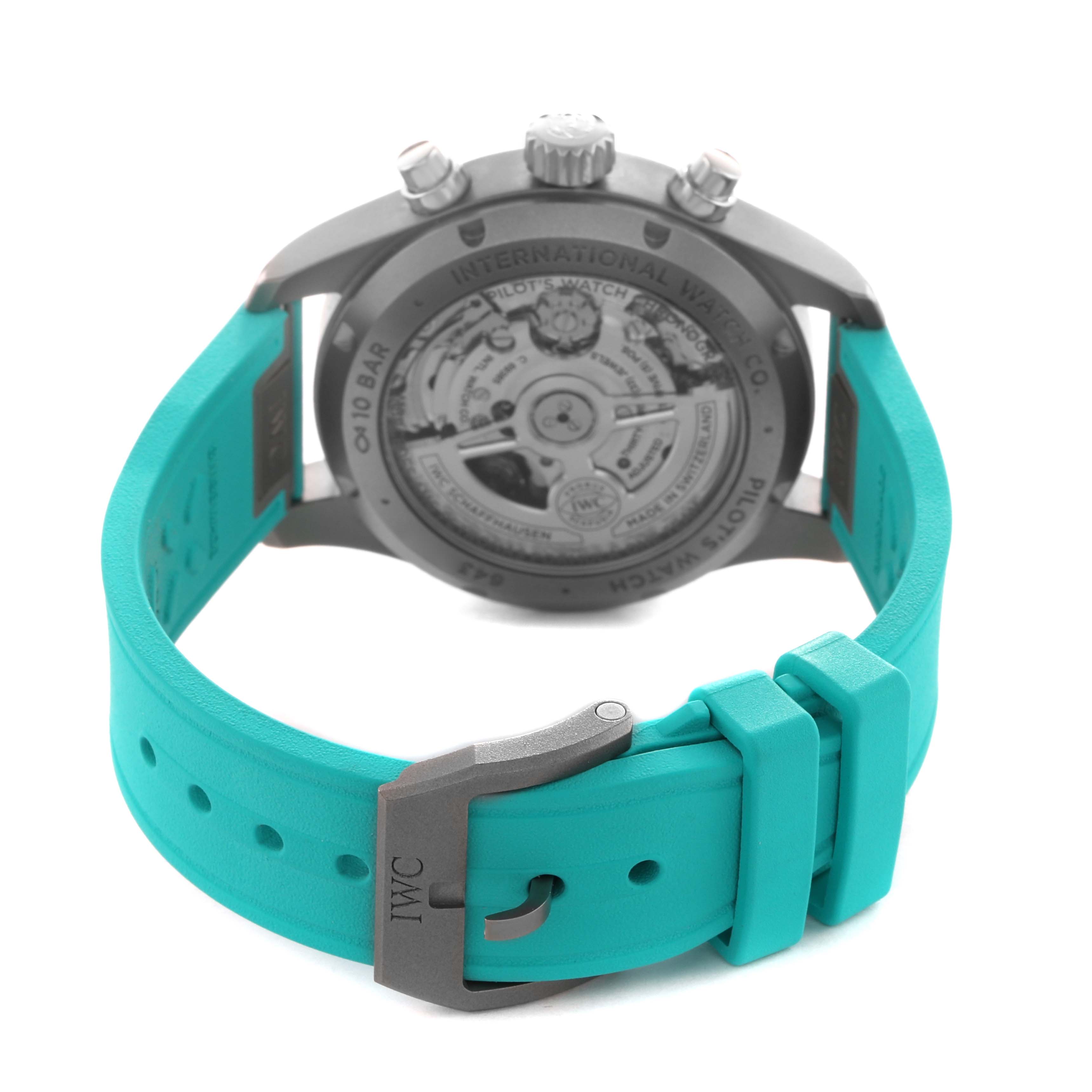 The image shows the back of the IWC Pilot IW388108 Men's Titanium Black Dial watch, highlighting the case back and turquoise strap with a metal buckle.