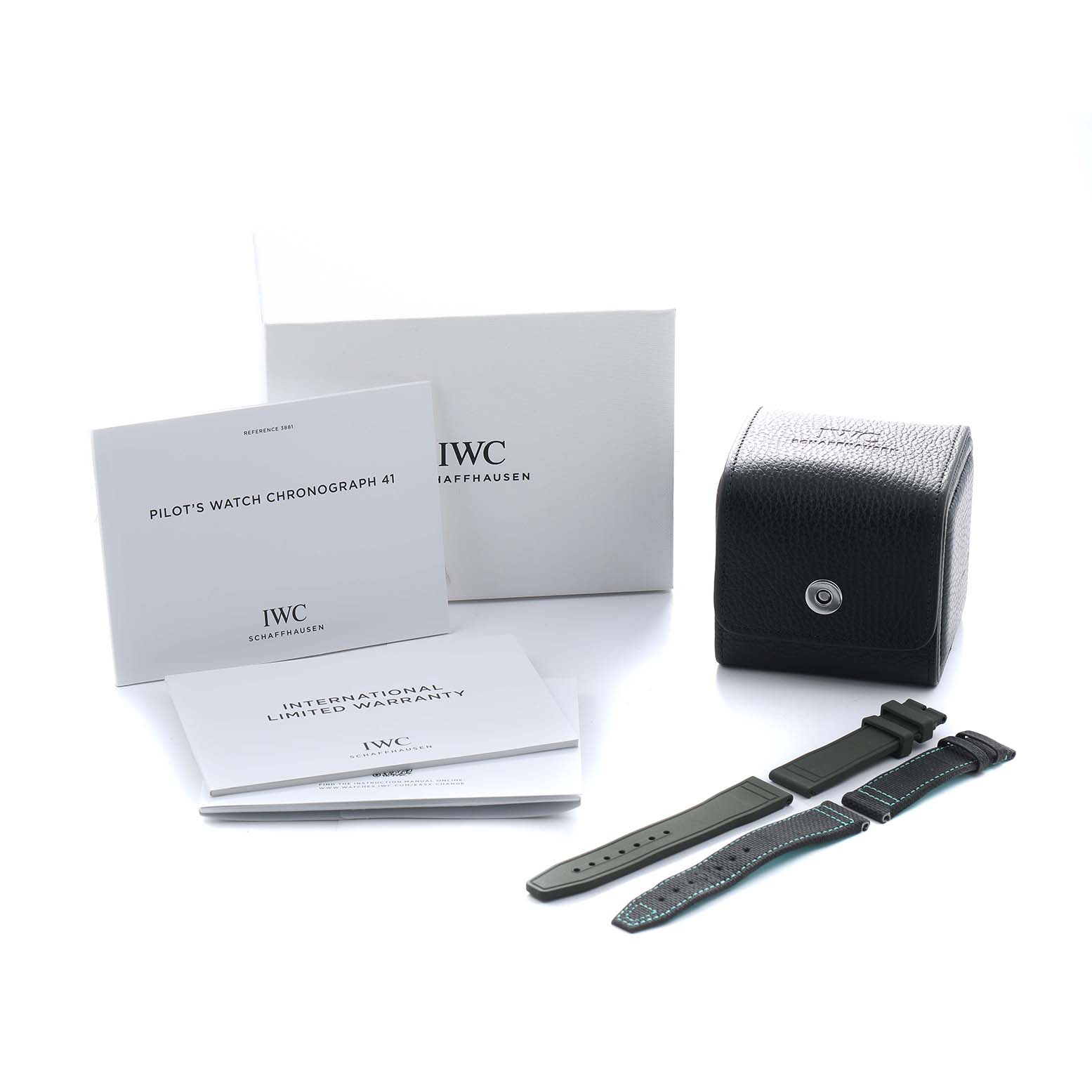 The image shows the IWC Pilot IW388108 Men's Titanium Black Dial model's accessories, including a box, manual, warranty, and two straps from a front angle.