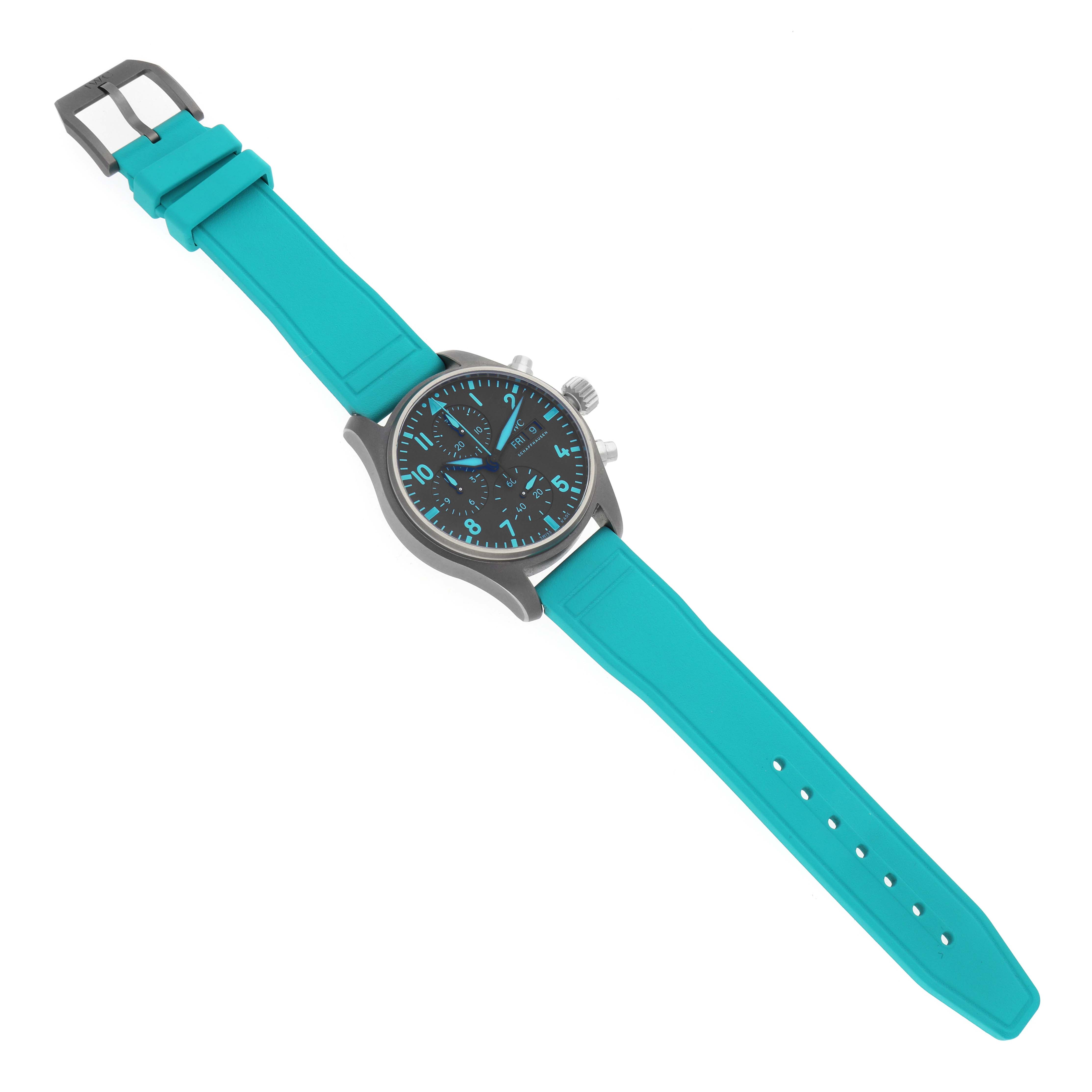 The IWC Pilot IW388108 Men's Titanium Black Dial watch is shown from a top view, highlighting the blue strap, watch face, and side pushers.