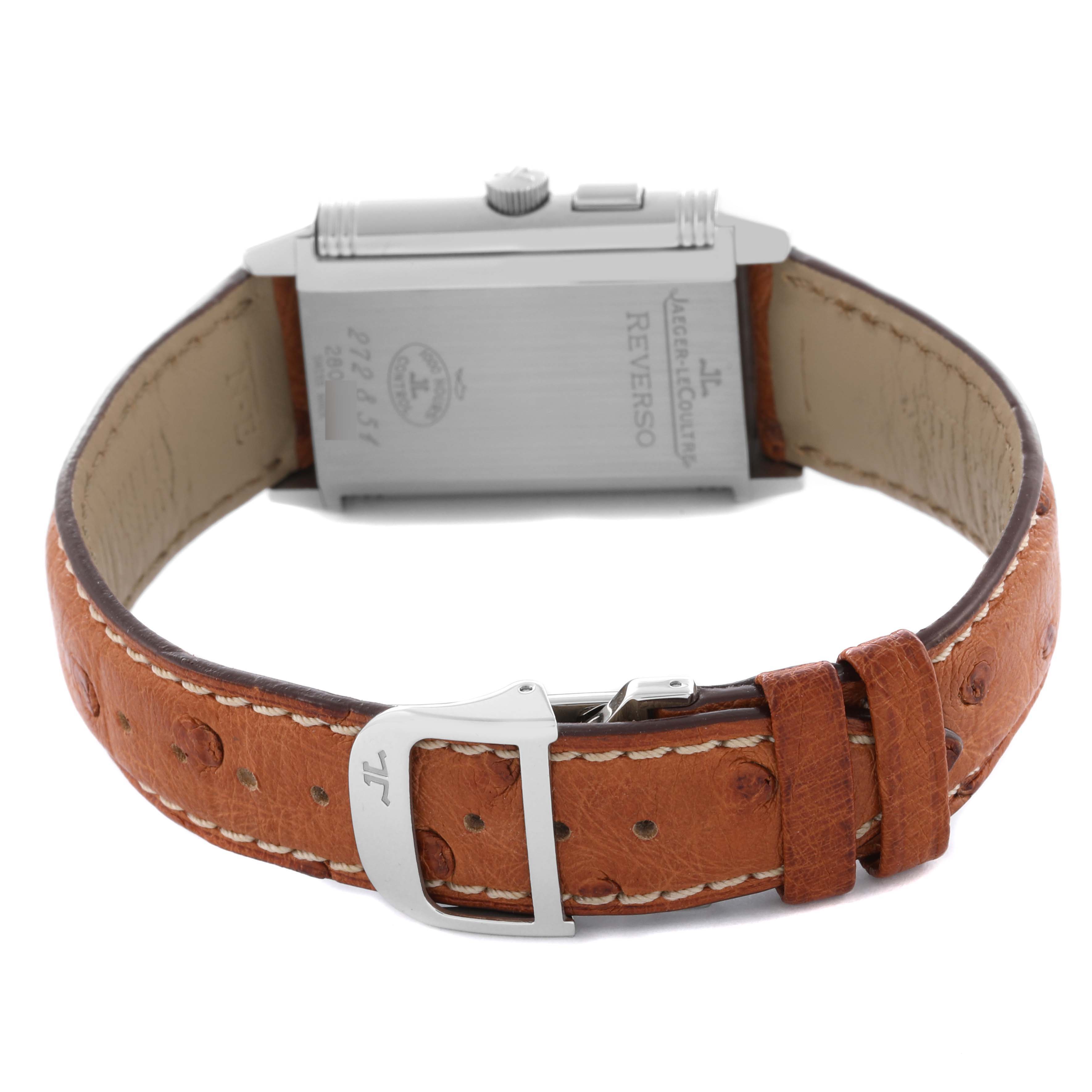 The Jaeger-LeCoultre Reverso watch is shown from the back, displaying the case and brown leather strap with buckle.