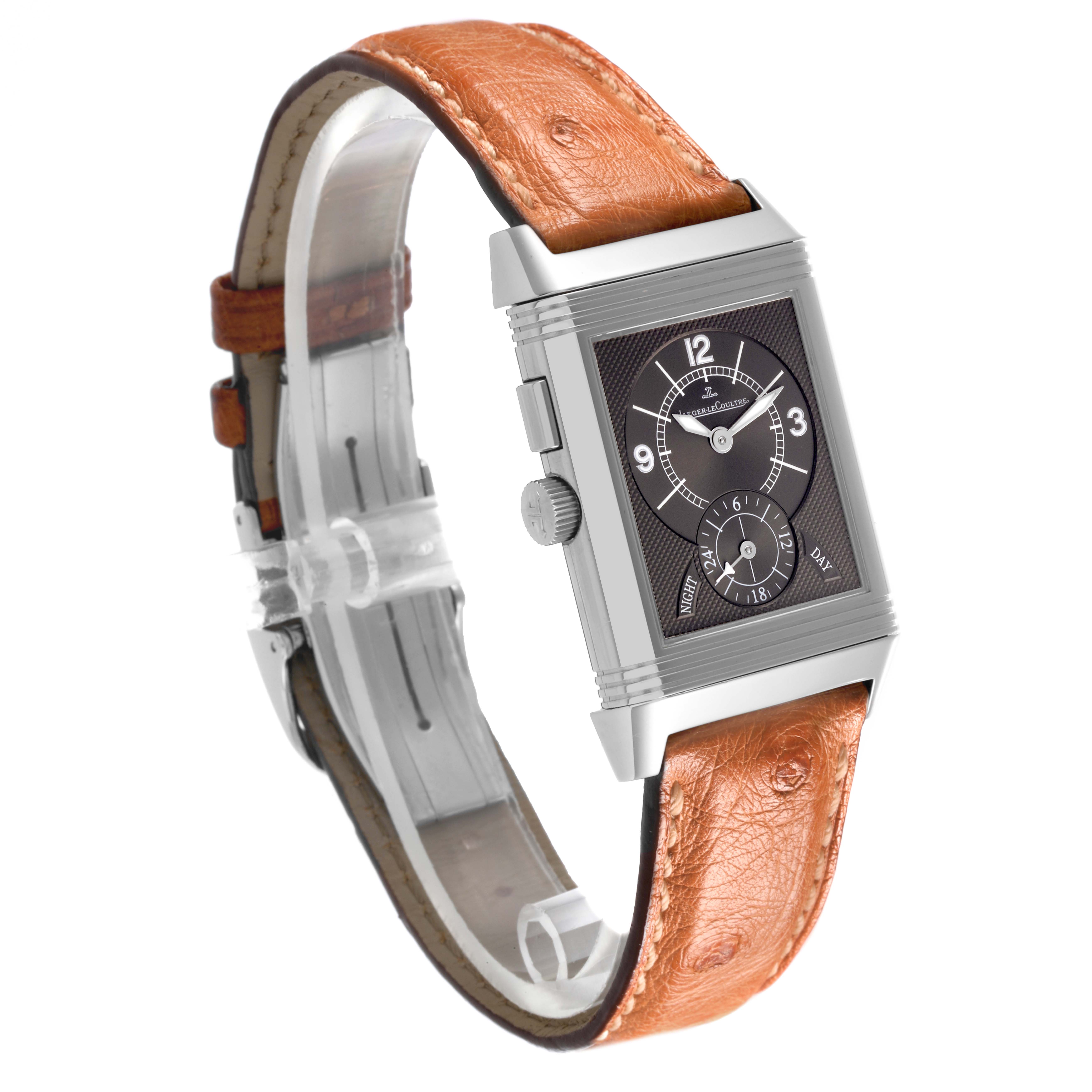 The Jaeger-LeCoultre Reverso watch is shown at an angled side view, highlighting the case, dial, crown, and leather strap.