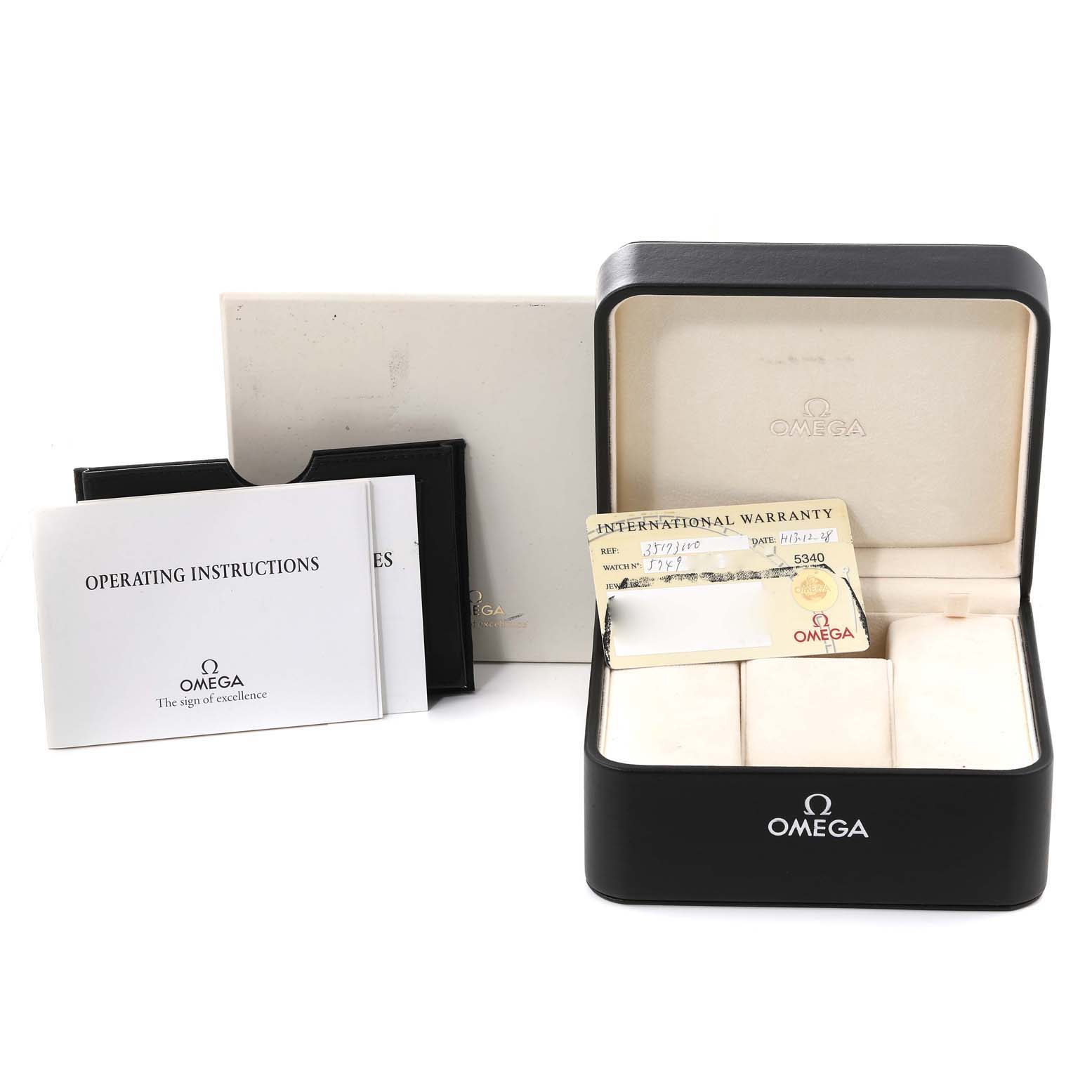 The image shows the packaging and accessories of an Omega Speedmaster 3517.30.00 Men's Stainless Steel Silver Dial 3517.30.00 Men's Stainless Steel Silver Dial watch, including the box, warranty card, and operating instructions.