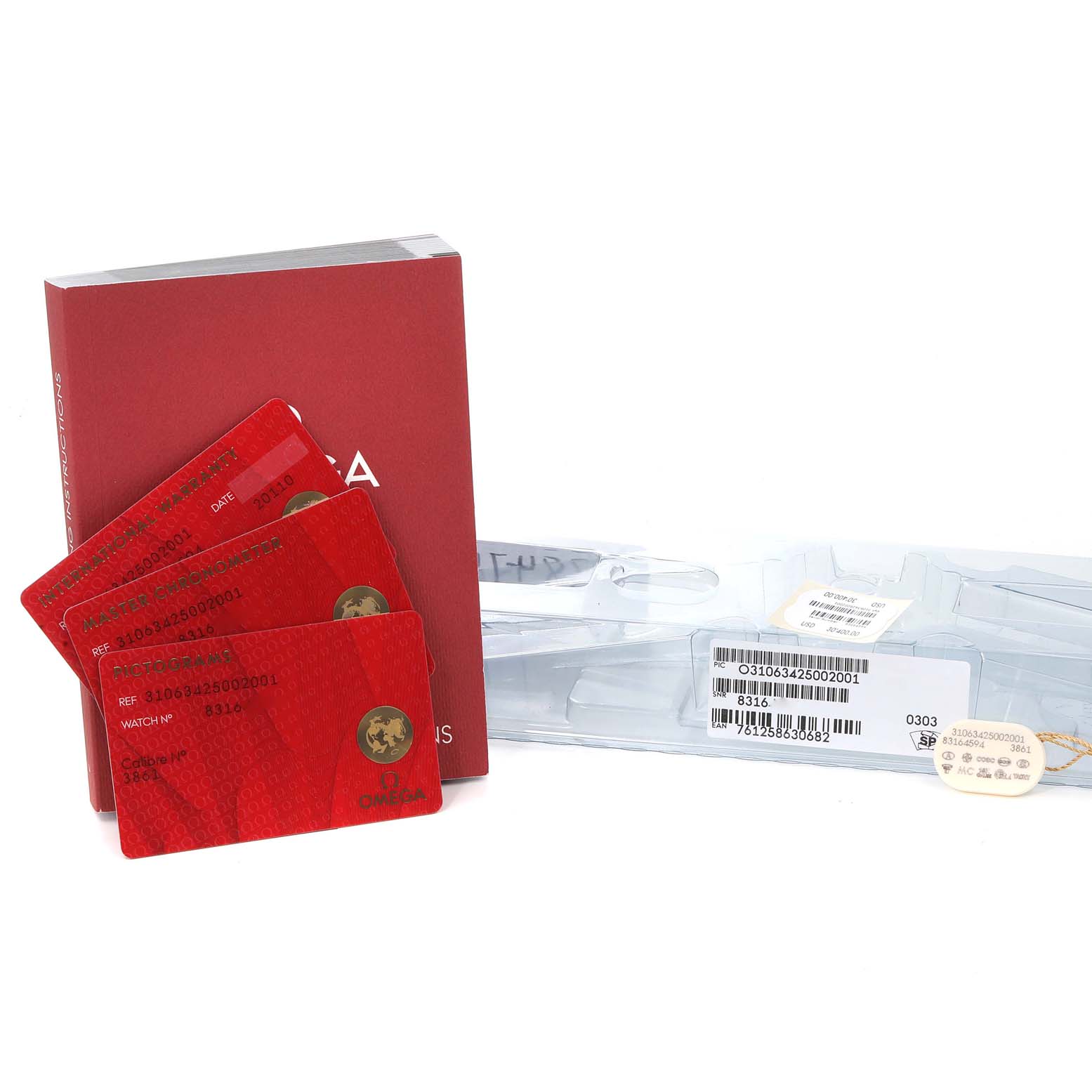 The image shows Omega Speedmaster 310.63.42.50.02.001 Men
s White Gold Silver Dial 310.63.42.50.02.001 Men
s White Gold Silver Dial cards, a manual, and packaging for the watch accessories.