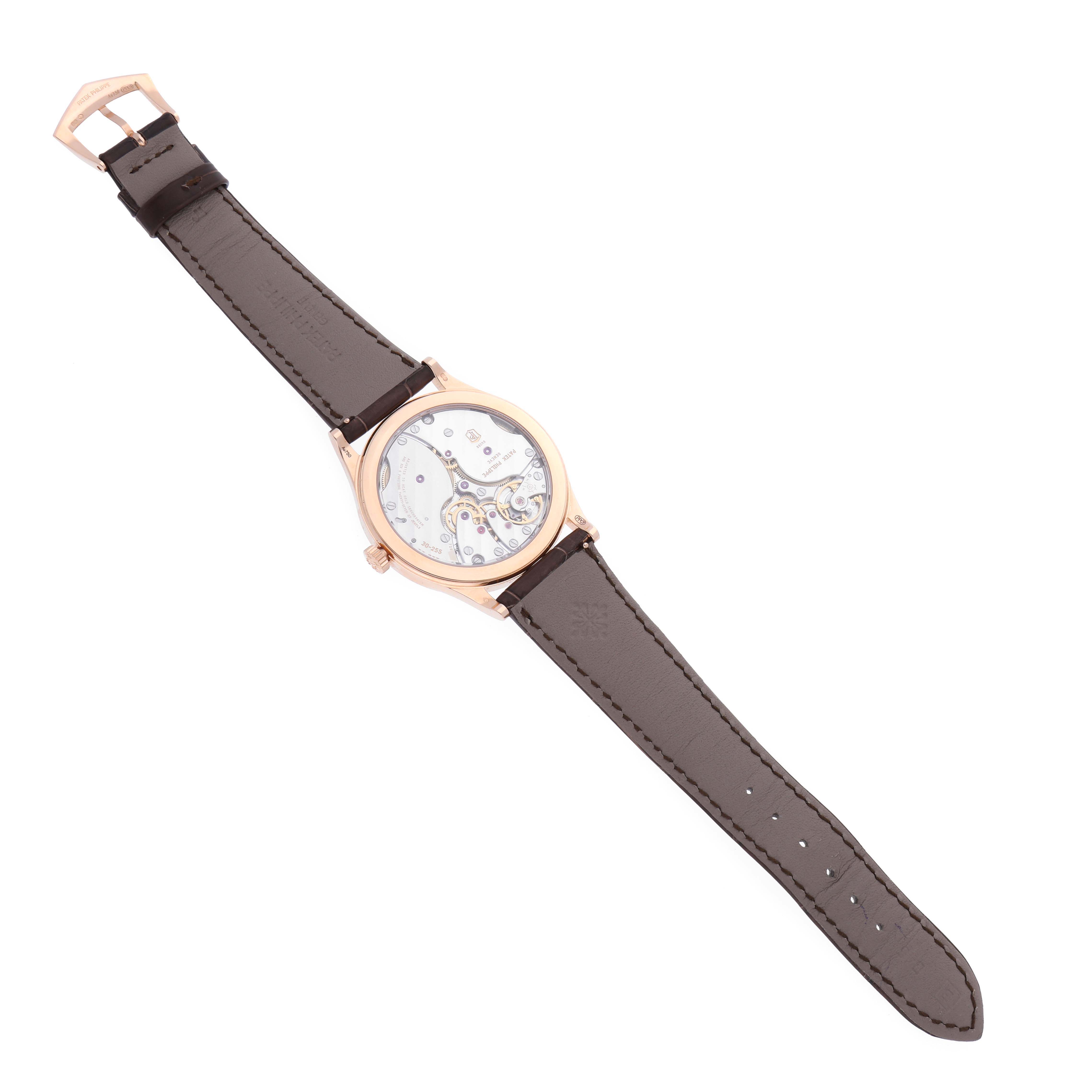 The Patek Philippe Calatrava 6119R-001 Men's Rose Gold Silver Dial 6119R-001 Men's Rose Gold Silver Dial watch is shown from a top view, highlighting its leather strap and transparent case back.