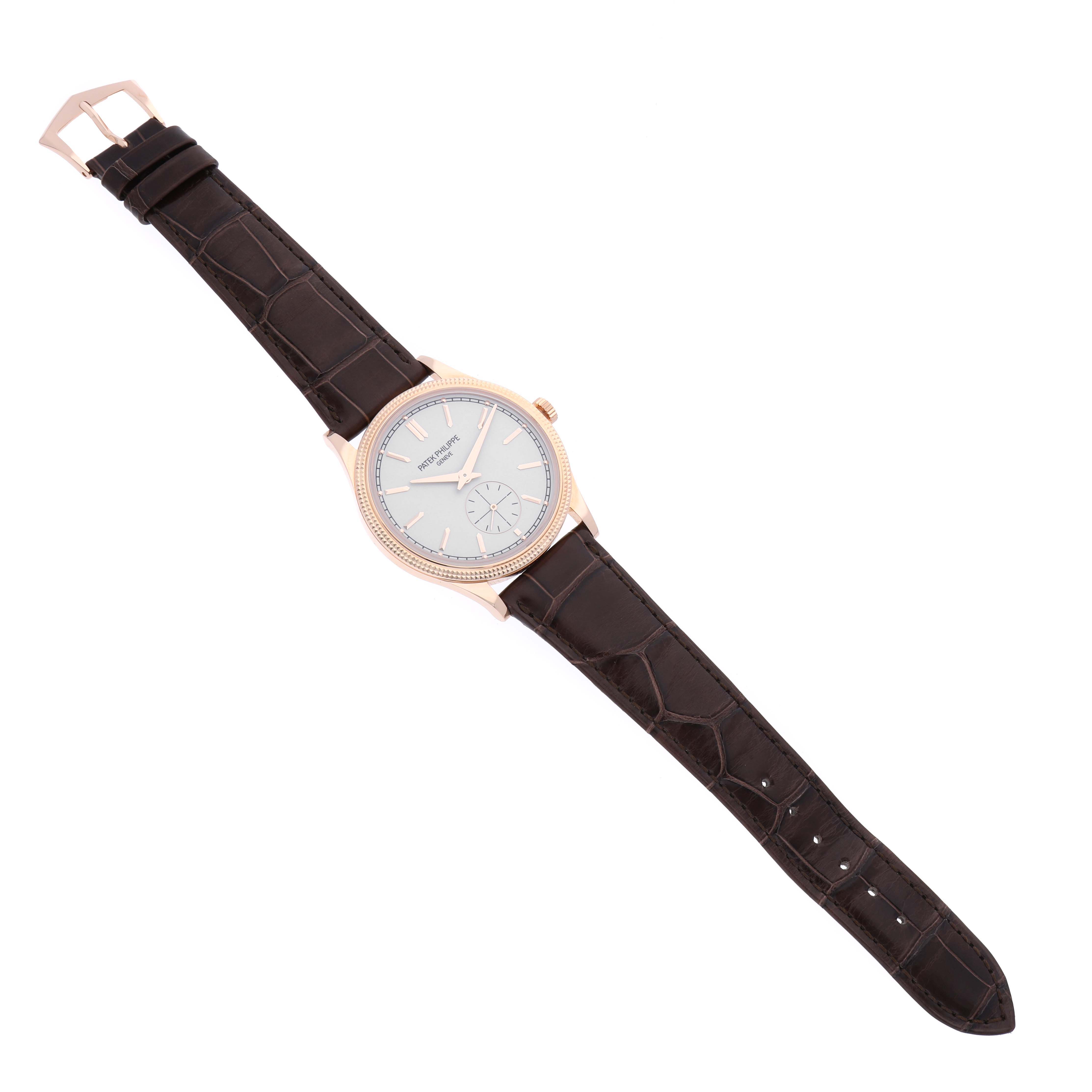 The Patek Philippe Calatrava 6119R-001 Men's Rose Gold Silver Dial 6119R-001 Men's Rose Gold Silver Dial watch is shown from a top-down angle, displaying the face, strap, and buckle.