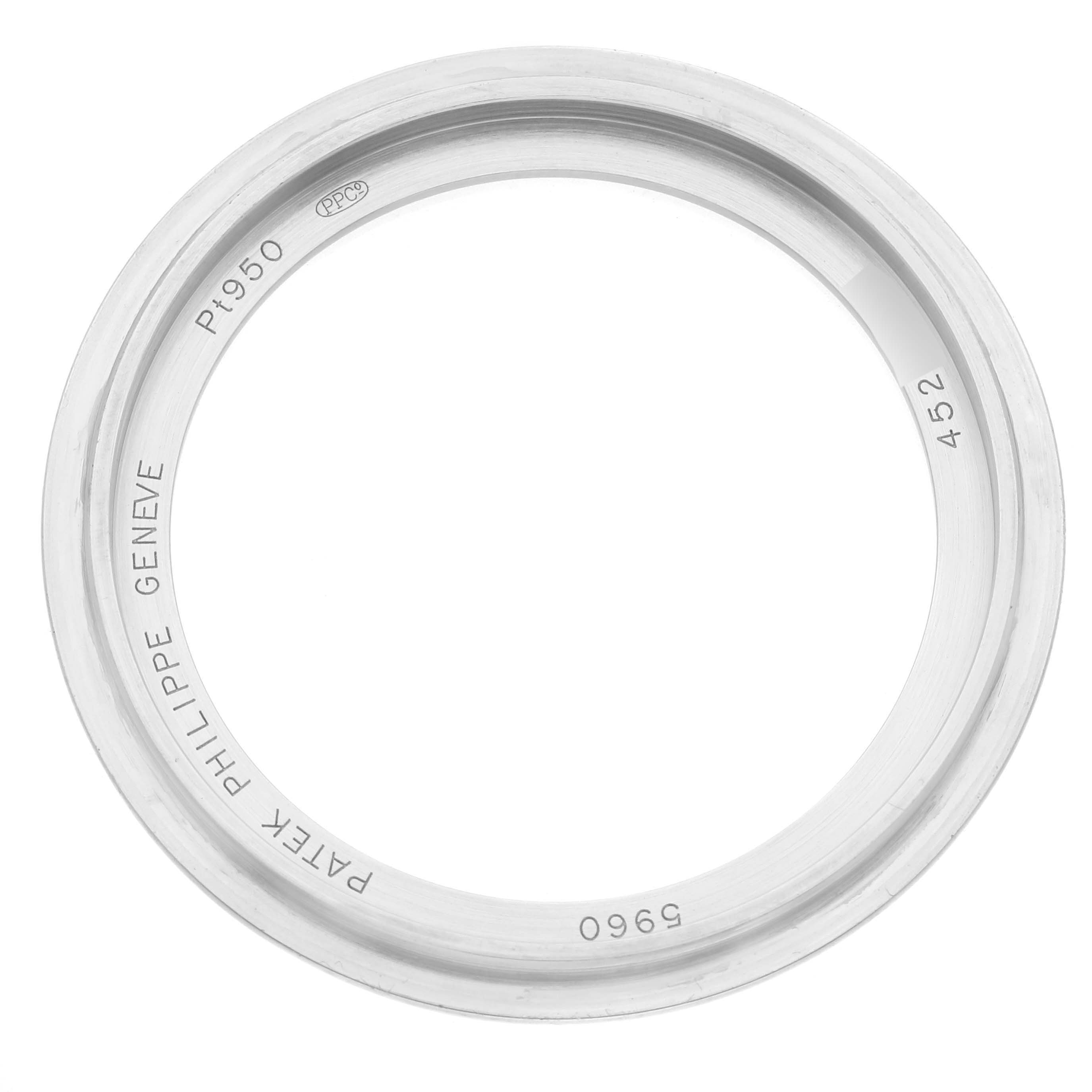 The image shows the bezel of a Patek Philippe Complications 5960P-015 Men's Platinum Blue Dial 5960P-015 Men's Platinum Blue Dial watch, displaying engravings and a top-down view.