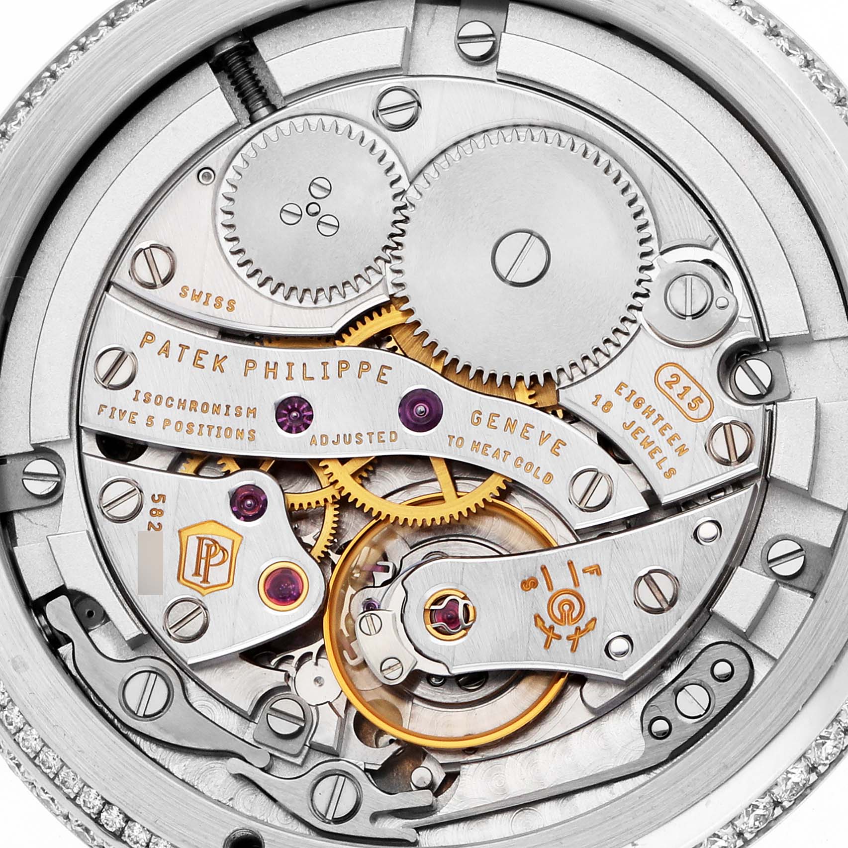 The image shows the intricate movement of a Patek Philippe Complications 4968G-010 Women's White Gold Mother of Pearl Dial watch from a top-down angle, highlighting gears and mechanisms.