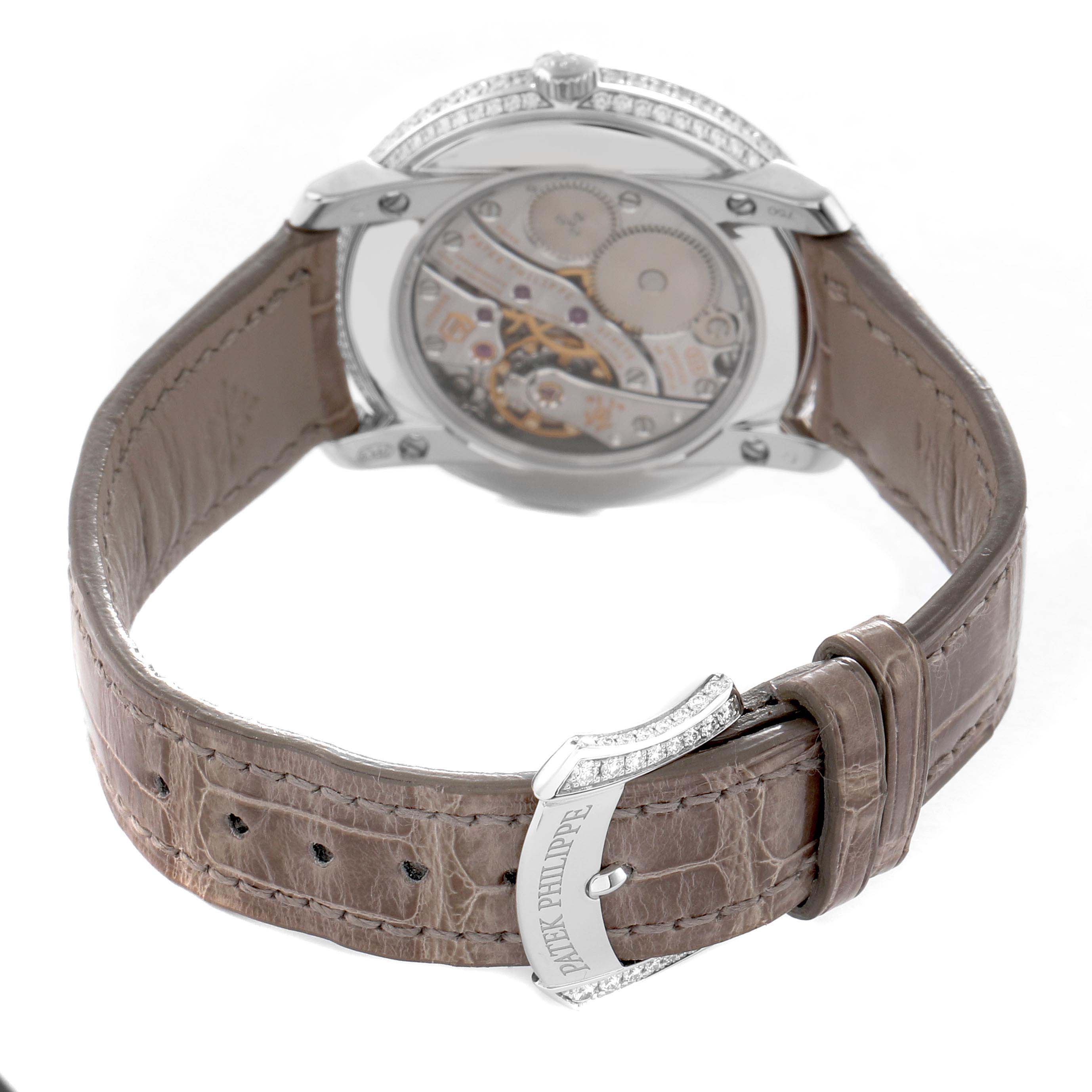 The image shows the back of a Patek Philippe Complications 4968G-010 Women's White Gold Mother of Pearl Dial watch, highlighting the movement and leather strap with branded clasp.