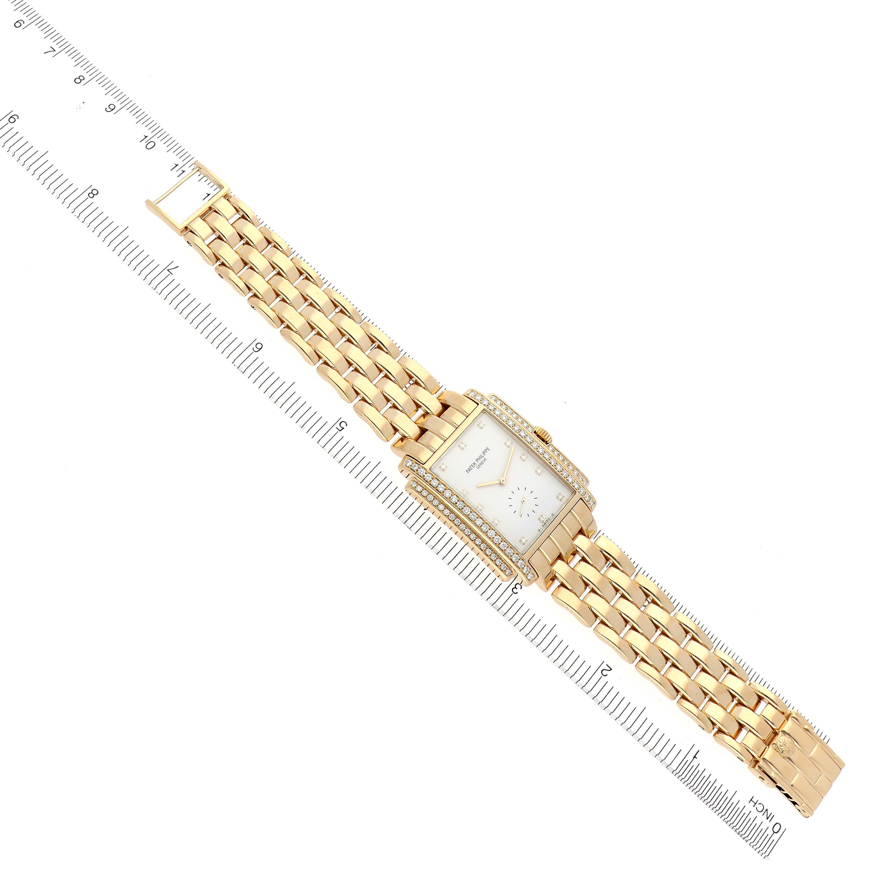 The image shows a top-down view of the Patek Philippe Gondolo 5025/1J Men's Yellow Gold White Dial 5025/1J Men's Yellow Gold White Dial watch, displaying its face, bracelet, and a ruler for scale.