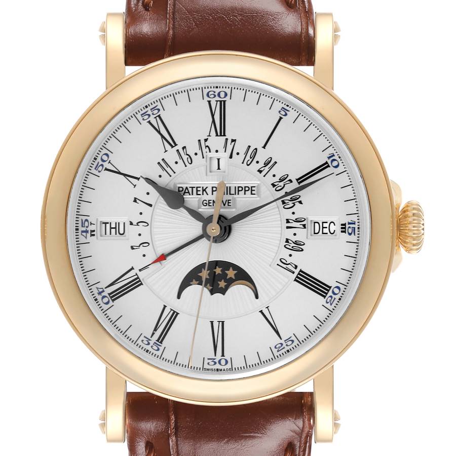 The Patek Philippe Complications watch is shown from a front angle, displaying its face, gold case, crown, and brown leather strap.