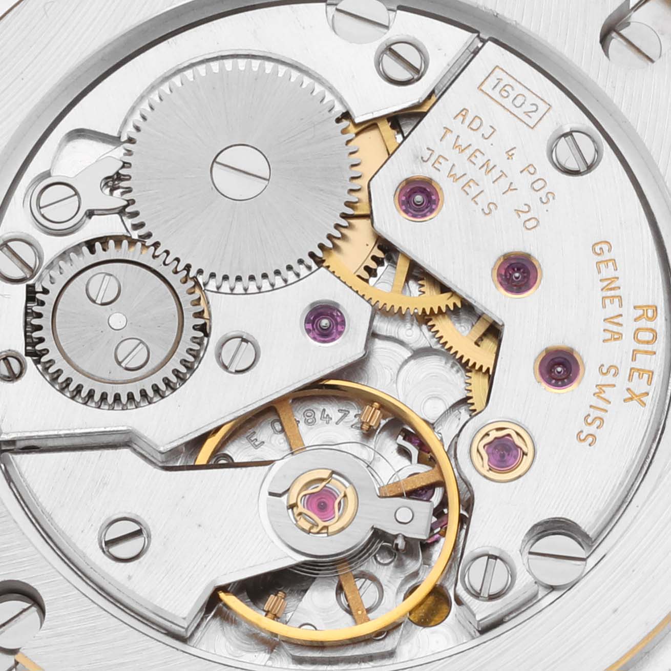 The image shows a close-up of the Rolex Cellini 5115 Men's Yellow Gold Silver Dial 5115 Men's Yellow Gold Silver Dial watch movement, revealing gears, jewels, and inscriptions.