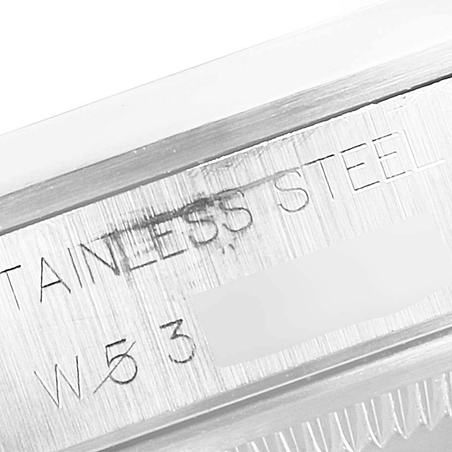 The image shows a close-up of the engraved "STAINLESS STEEL" and partial serial number on the case of a Rolex Date 15200 Men's Stainless Steel White Dial 15200 Men's Stainless Steel White Dial model watch.