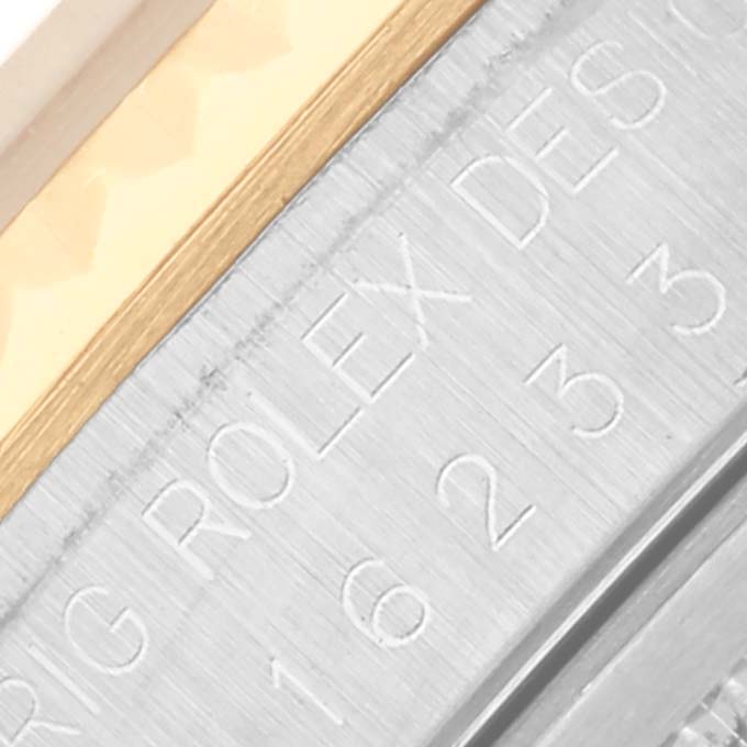 The image shows a close-up of the Rolex Datejust 16233 Men's Steel and Gold (two tone) Champagne Dial 16233 Men's Steel and Gold (two tone) Champagne Dial's engraved inner bezel and part of the metal edge.