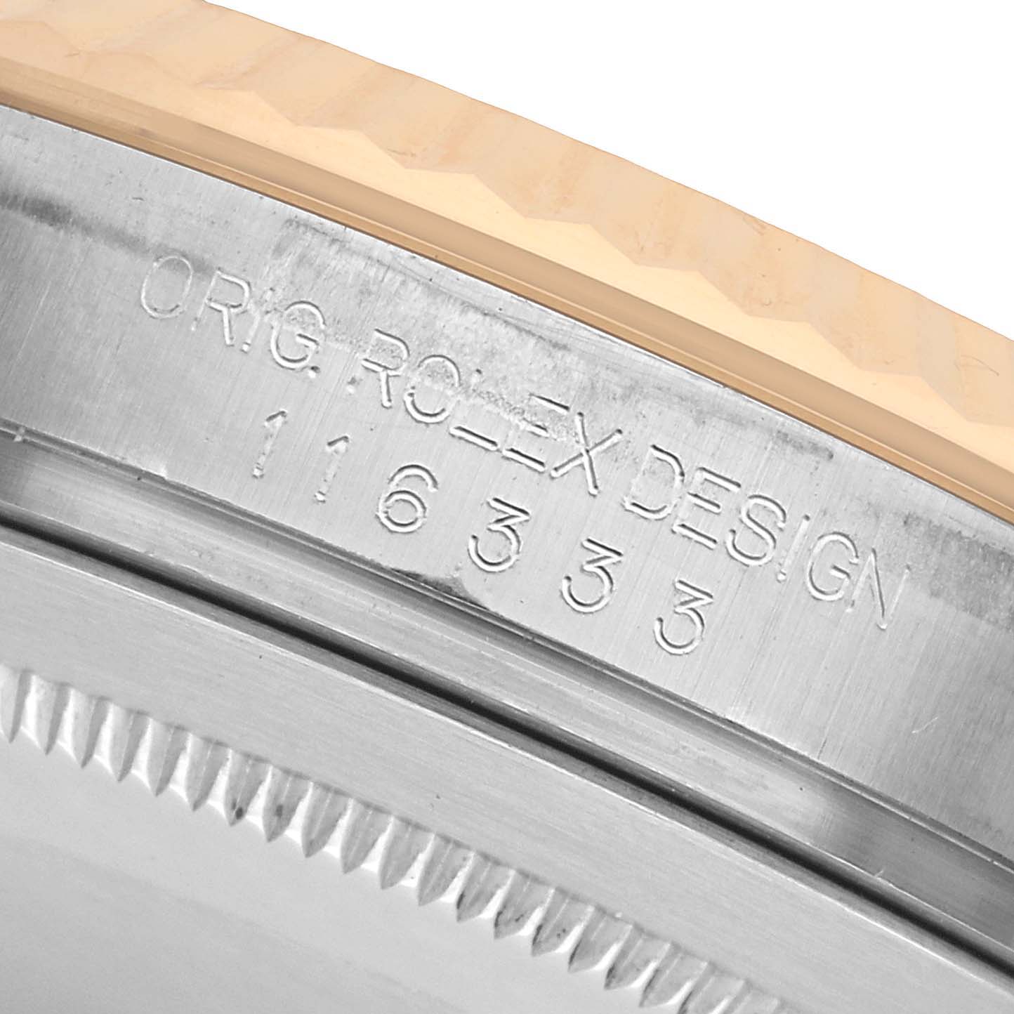 The image shows a close-up of the Rolex Datejust 41 116333 Men's Steel and Gold (two tone) Champagne Dial, focusing on the bezel edge and the engraved design number.