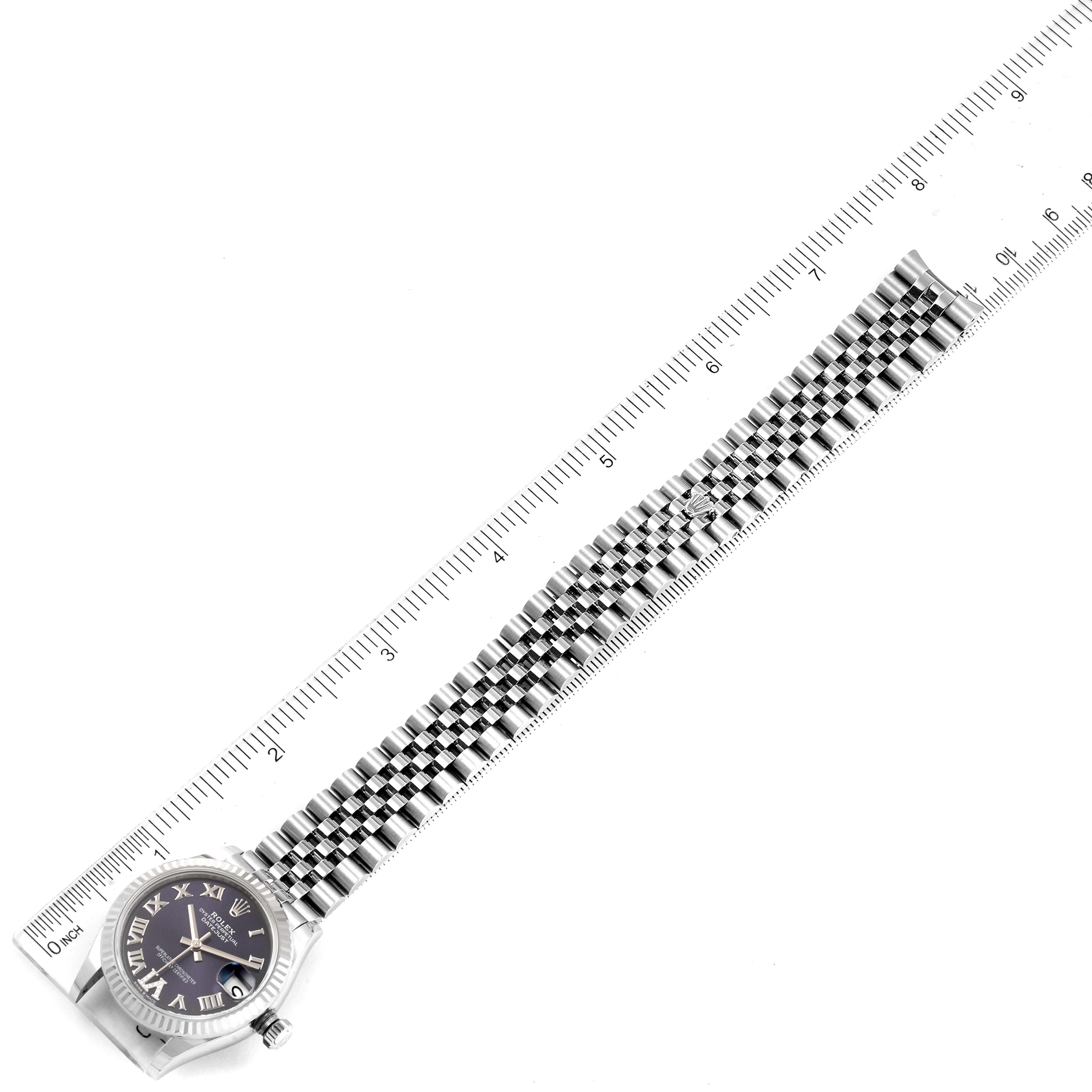 The image shows a Rolex Mid-Size 278274 Women
s Stainless Steel Blue Dial 278274 Women
s Stainless Steel Blue Dial model watch laid flat, with a ruler beside it to measure its length, displaying the face and full bracelet.