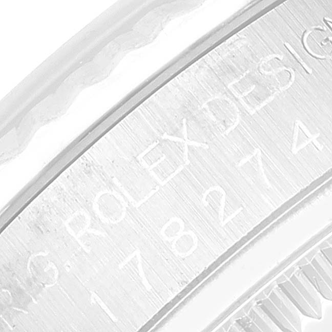 The image shows a close-up view of the edge of a Rolex Mid-Size 178274 Women
s Stainless Steel White Dial 178274 Women
s Stainless Steel White Dial watch, focusing on the engraved "Rolex Design" marking.