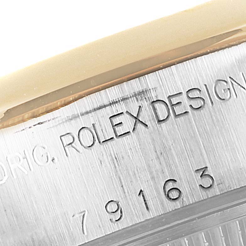 This image shows an angled close-up of the engraved case side of a Rolex Datejust 79163 Women's Steel and Gold (two tone) Black Dial 79163 Women's Steel and Gold (two tone) Black Dial watch, including part of the model number.