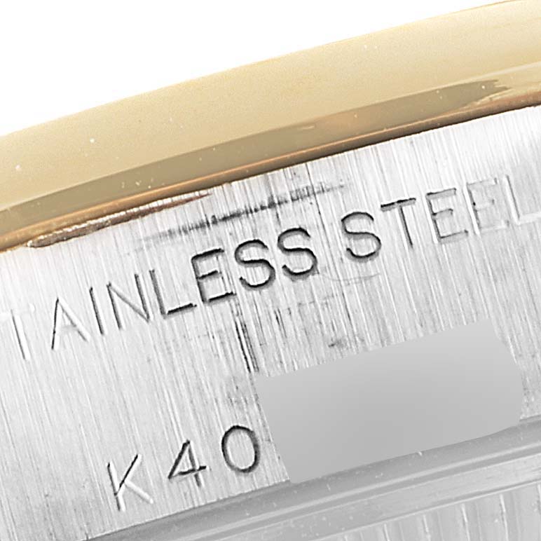 This close-up image shows the edge and serial engraving on the stainless steel case of a Rolex Datejust 79163 Women's Steel and Gold (two tone) Black Dial 79163 Women's Steel and Gold (two tone) Black Dial watch.