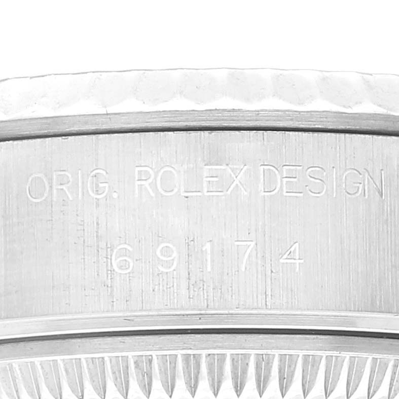 This close-up image of a Rolex Datejust 69174 Women's Stainless Steel Black Dial 69174 Women's Stainless Steel Black Dial shows its case with the engraving "ORIG. ROLEX DESIGN 69174".